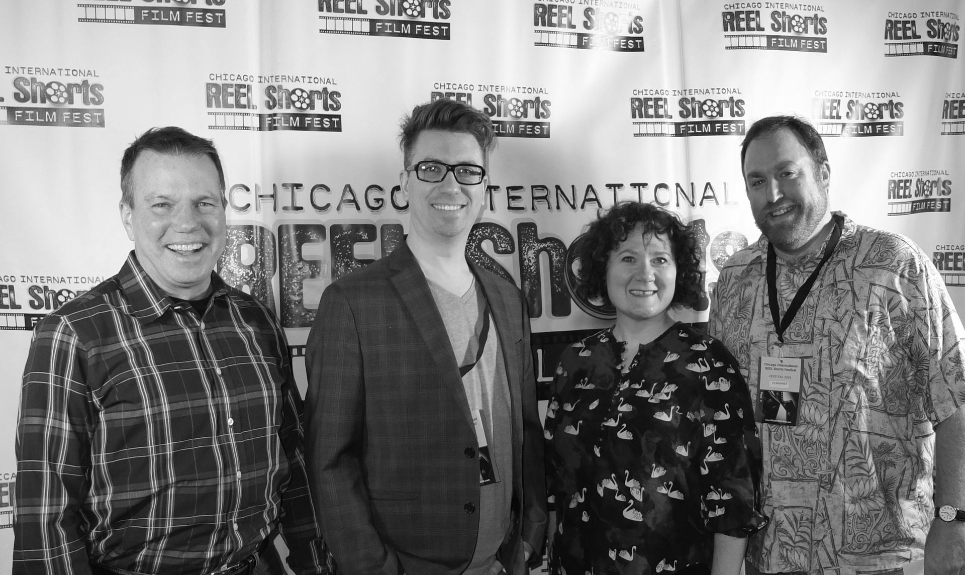 Four people posing at a Chicago film festival. The backdrop reads 