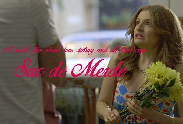 A woman is holding a bouquet of flowers in front of a sign that says sao de merde