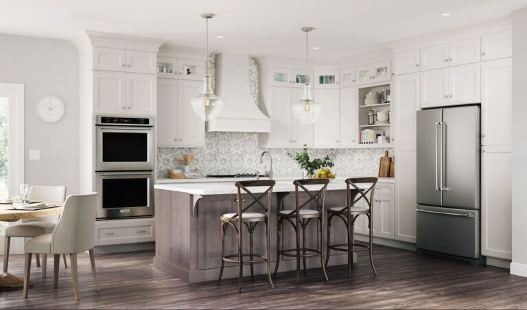 Bright white kitchen with a gray island and stainless steel appliances.