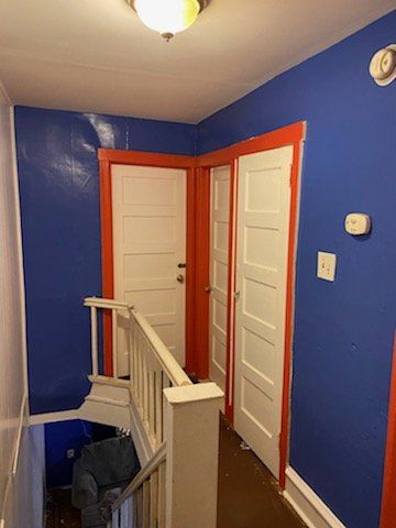 man on ladder painting the wall