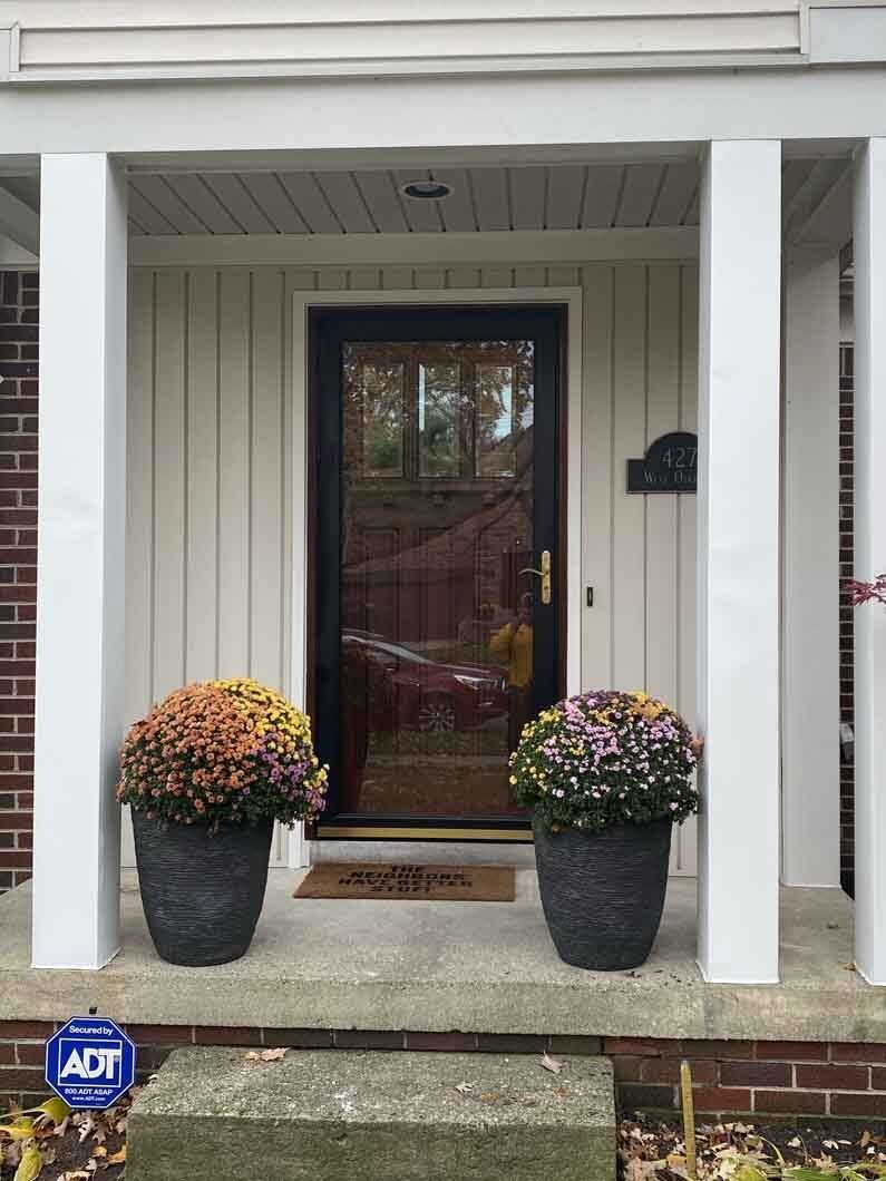 a front door with flowers in pots.