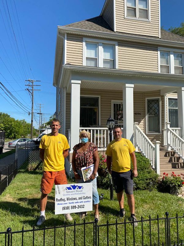 a group of people standing in front of a house.