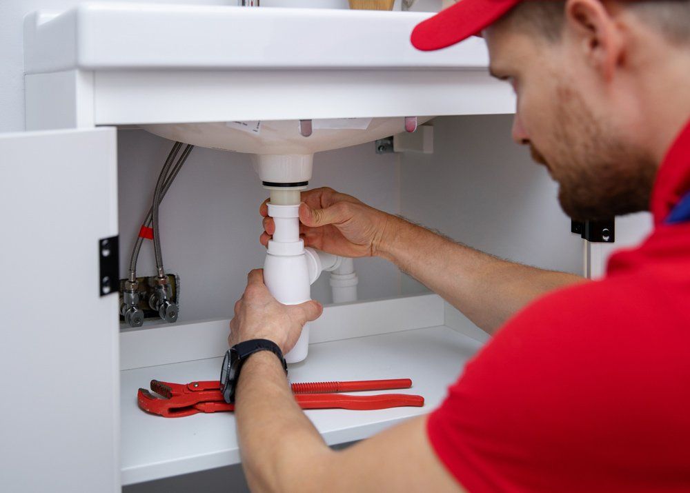 Plumber Installing Sink Siphon in Domestic Bathroom — Irwin, PA — Westmoreland Affordable Plumbing Heating & Cooling