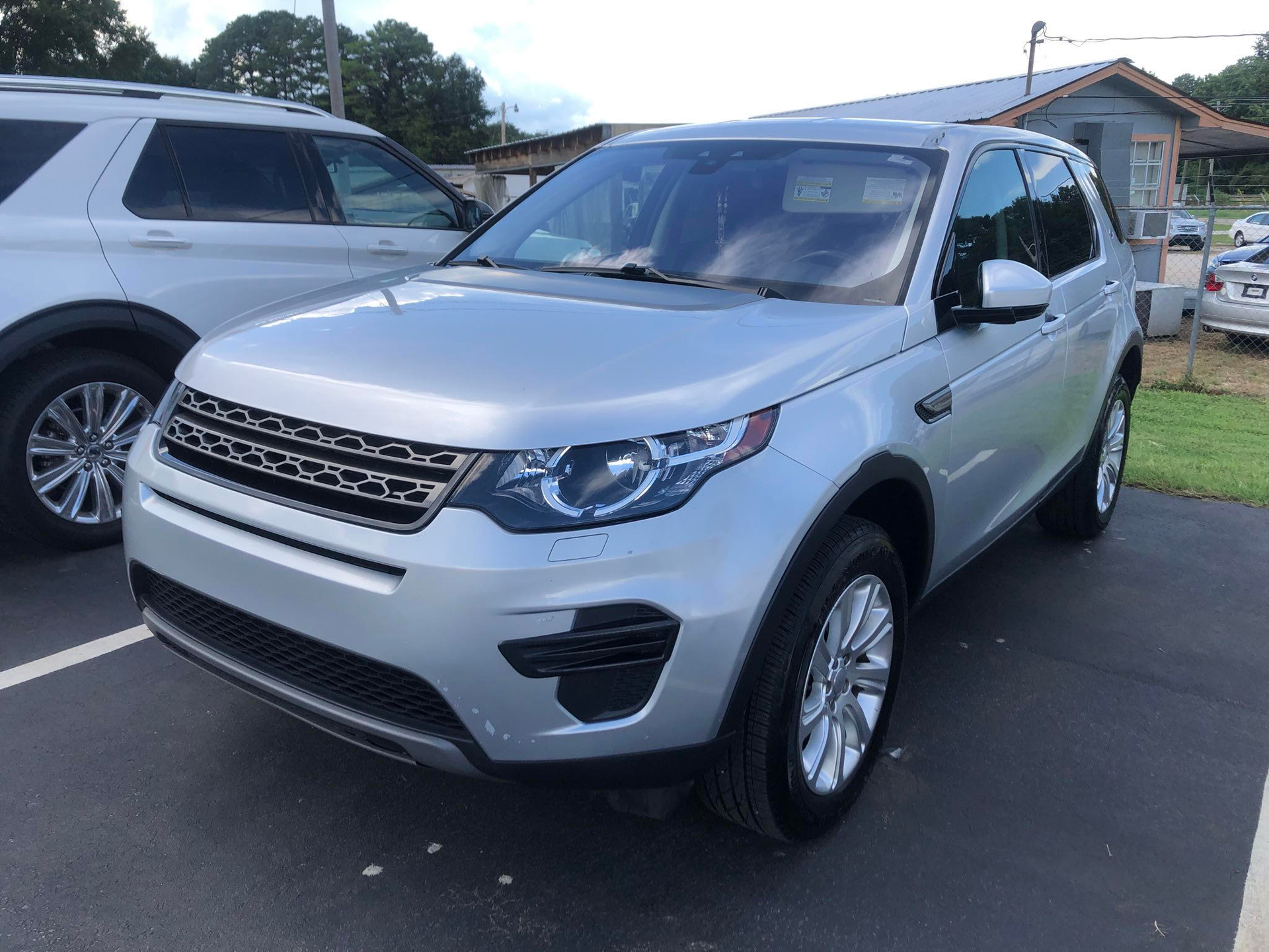 A silver land rover discovery is parked in a parking lot.  | Windham Bodyshop