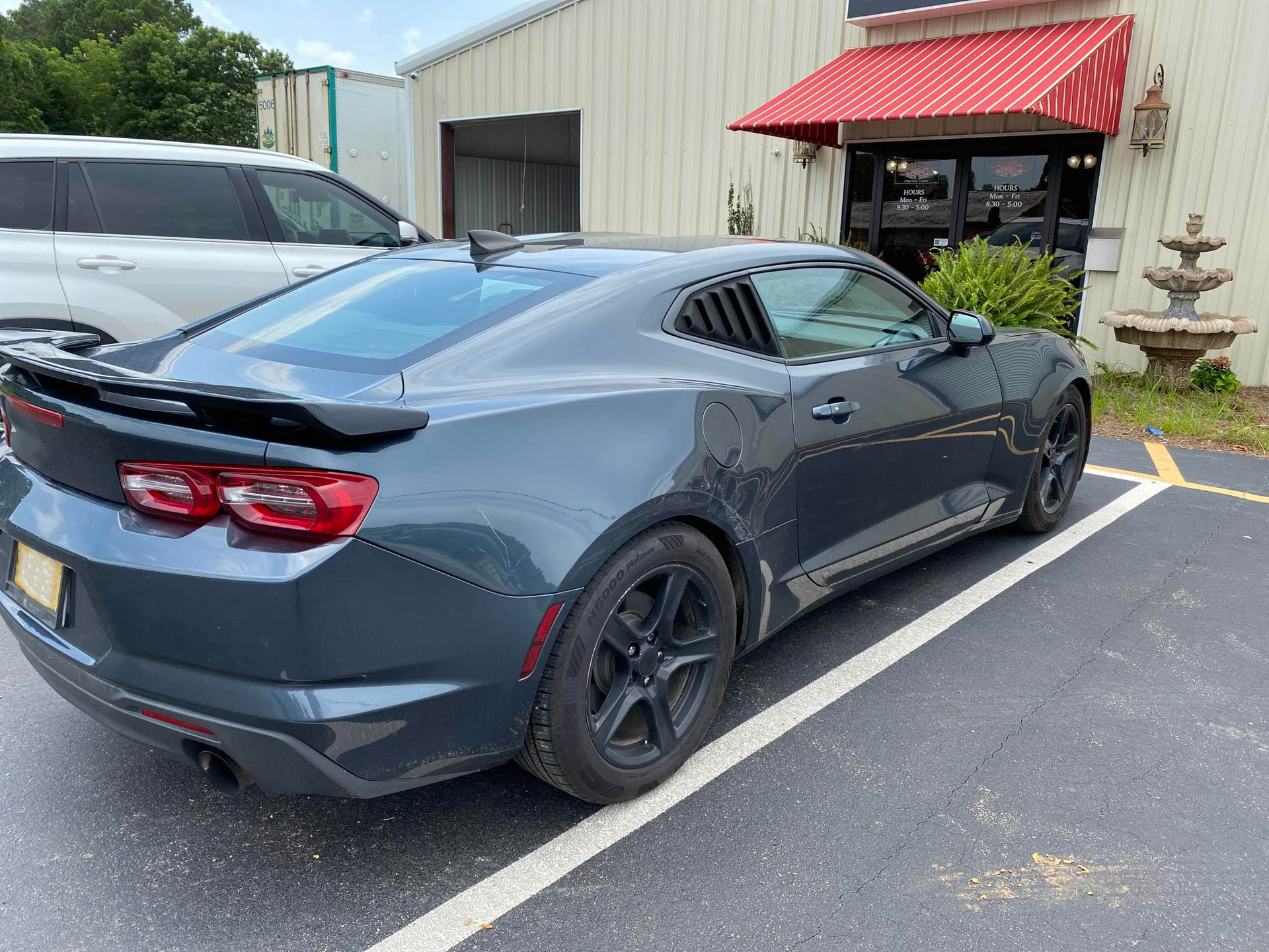A gray car is parked in a parking lot in front of a building.  | Windham Bodyshop