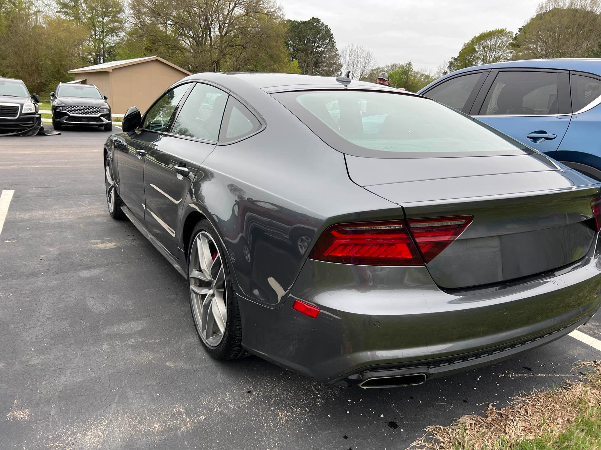 A gray car is parked in a parking lot next to other cars.  | Windham Bodyshop