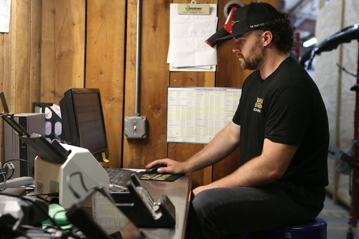 Our staff at our receptionist desk working on computer | Windham Bodyshop