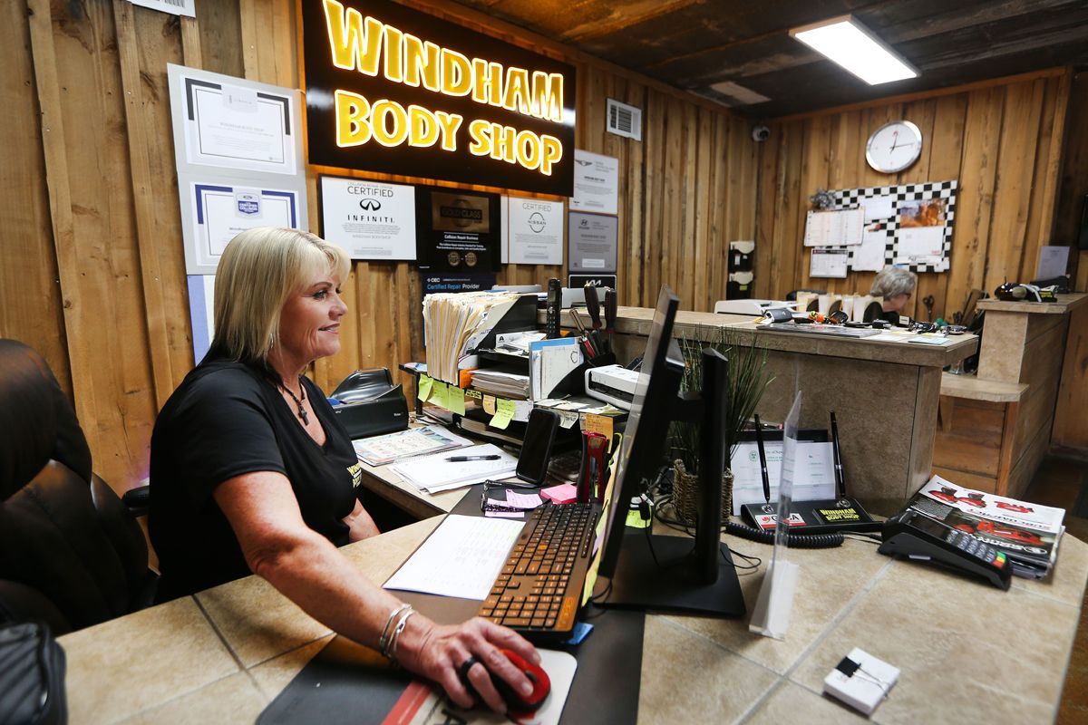 Our staff at our receptionist desk working on computer | Windham Bodyshop