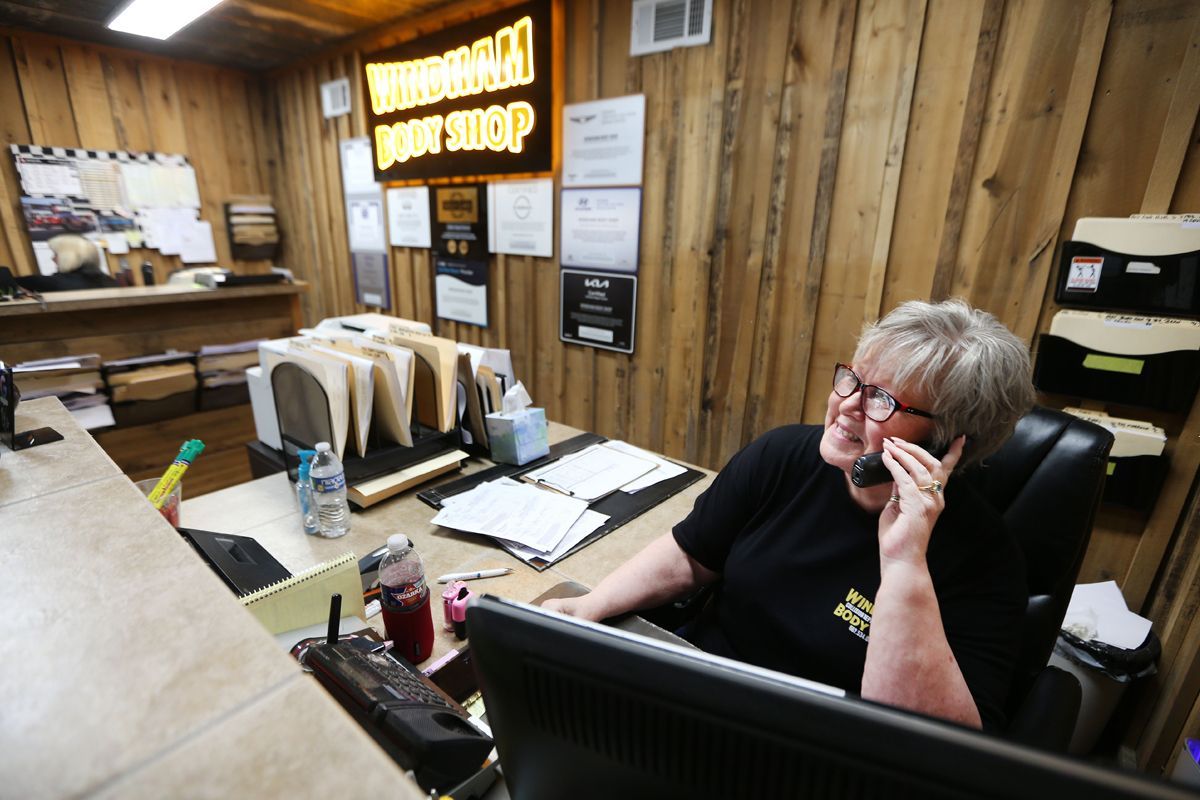 Our staff at our receptionist desk talking on phone and working on computer | Windham Bodyshop