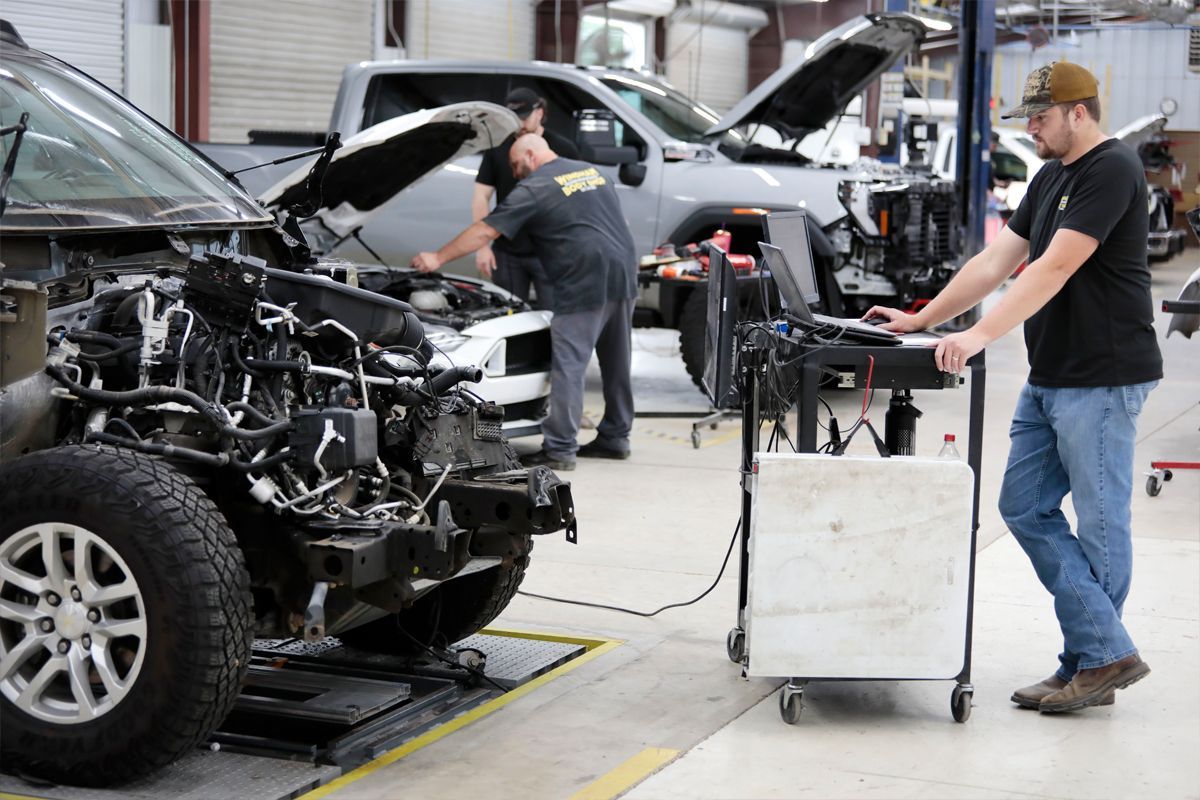 Inside our garage with our expert staff, repairing several cars | Windham Bodyshop