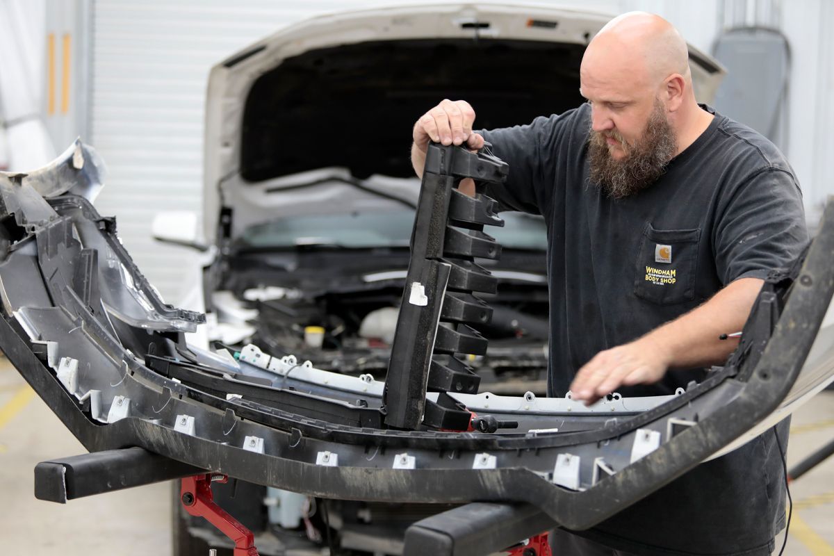Our expert staff in our garage repairing vehicle with hood up | Windham Bodyshop