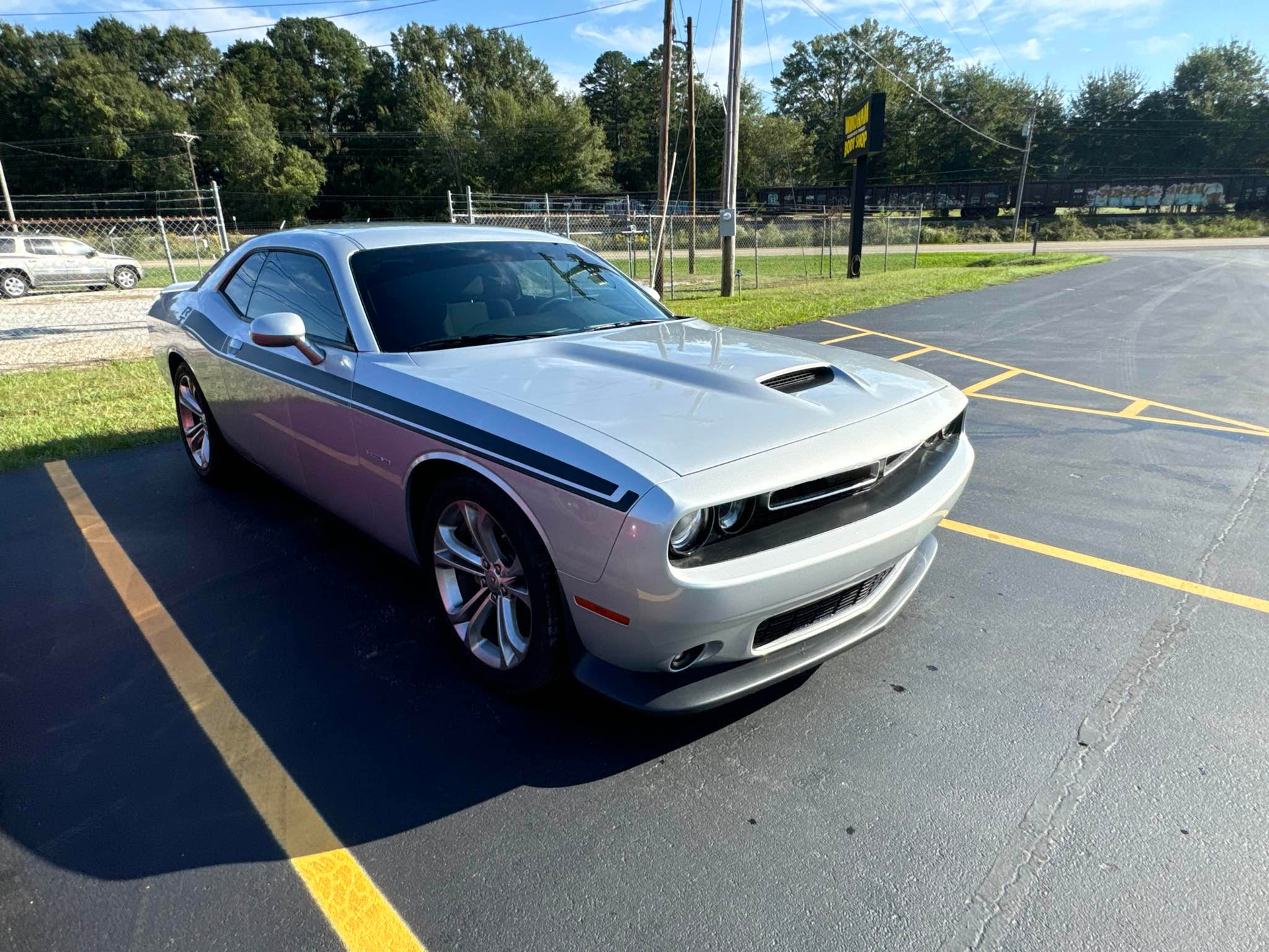 A silver dodge challenger is parked in a parking lot. | Windham Bodyshop