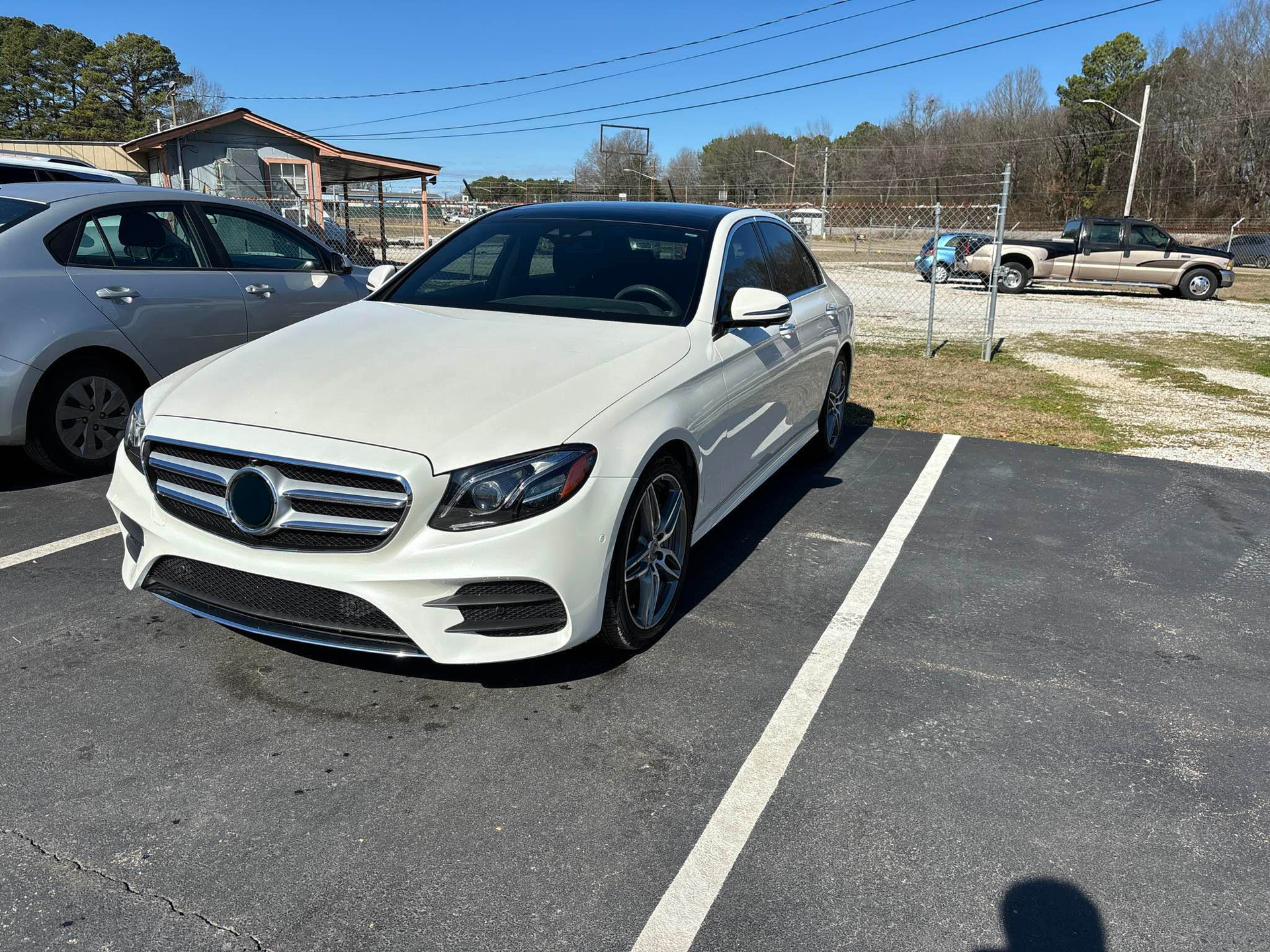 A white mercedes benz is parked in a parking lot.  | Windham Bodyshop