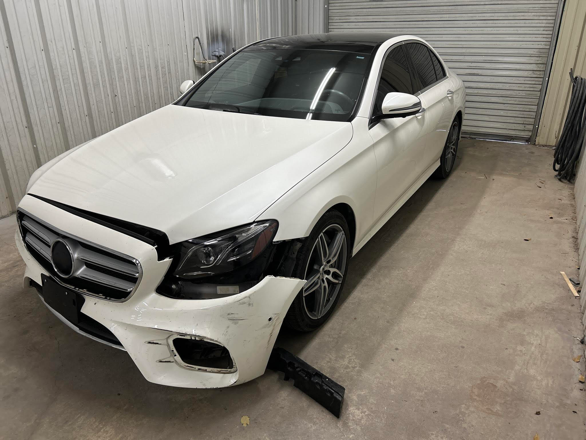 A white mercedes benz e class is parked in a garage.  | Windham Bodyshop