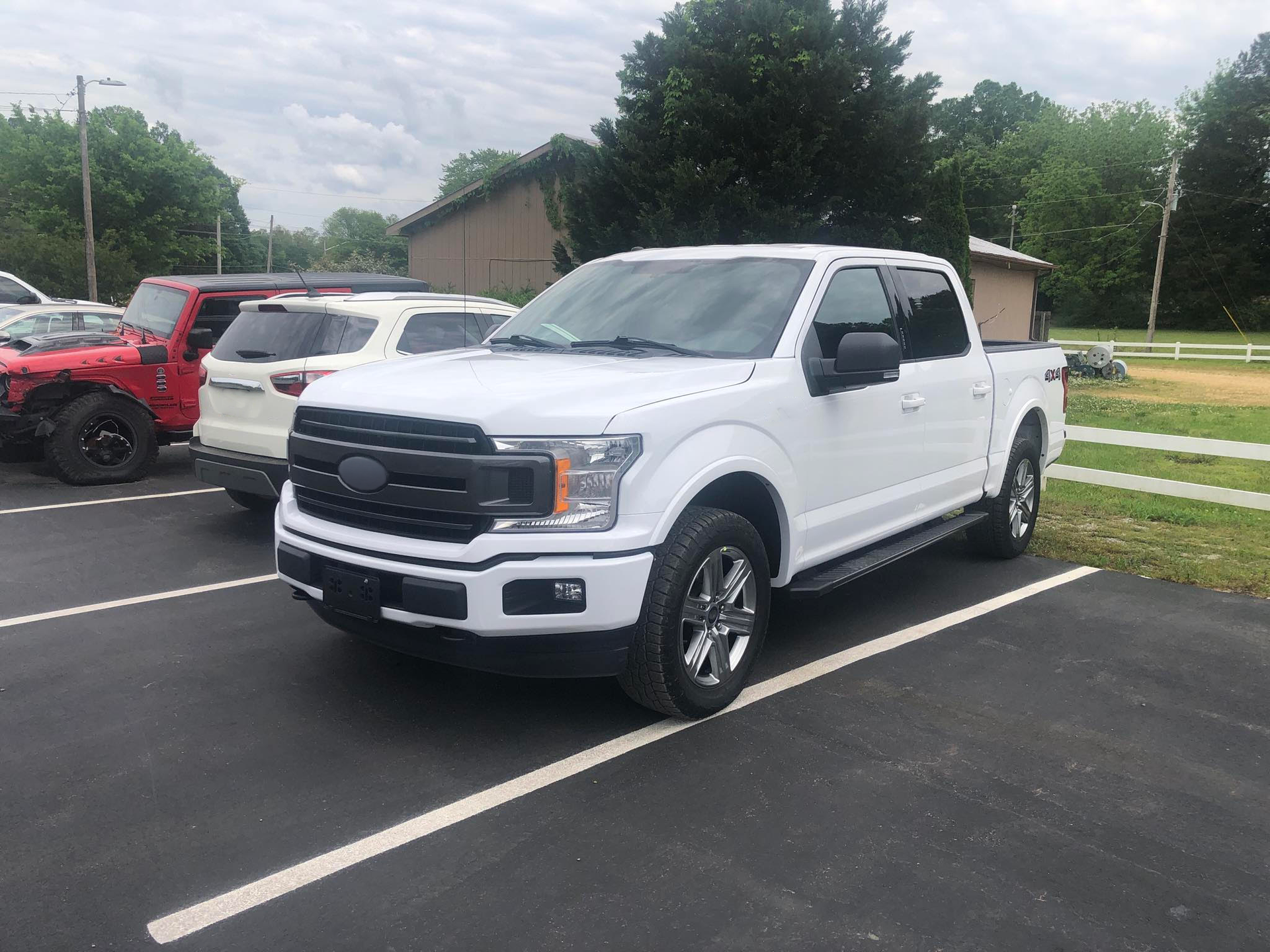 A white ford f150 truck is parked in a parking lot.  | Windham Bodyshop