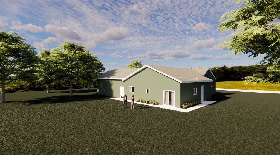 A green house with a white roof is sitting in the middle of a grassy field surrounded by trees.