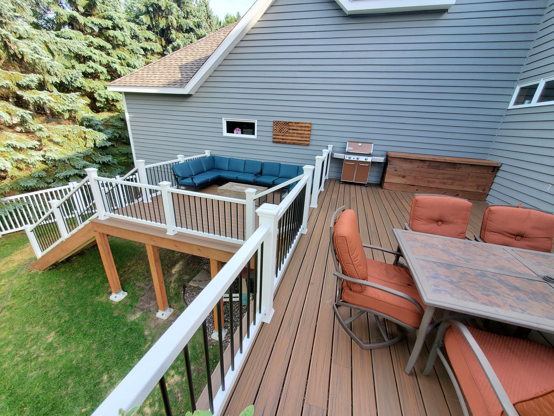 A large deck with a couch , table and chairs on it.