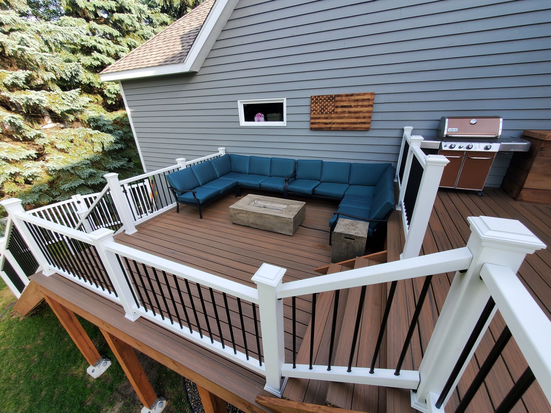 An aerial view of a deck with a couch and a grill.