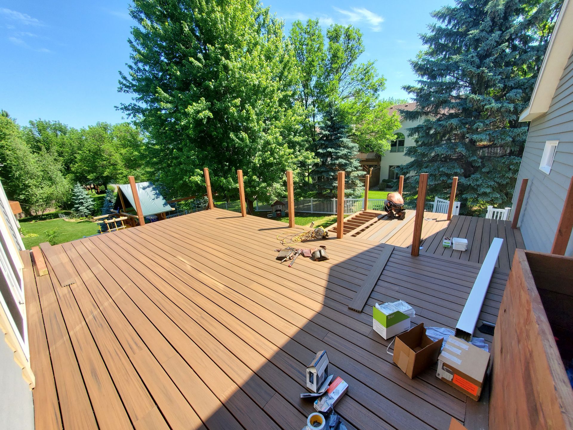 A wooden deck is being built in the backyard of a house.