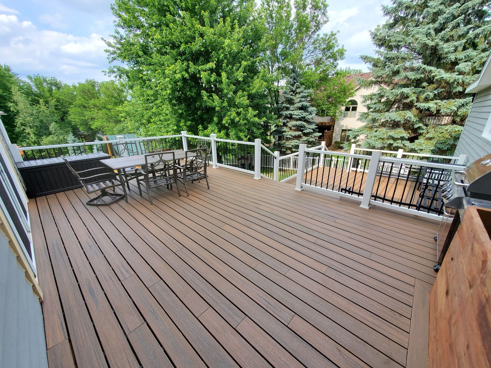 A large wooden deck with a table and chairs on it