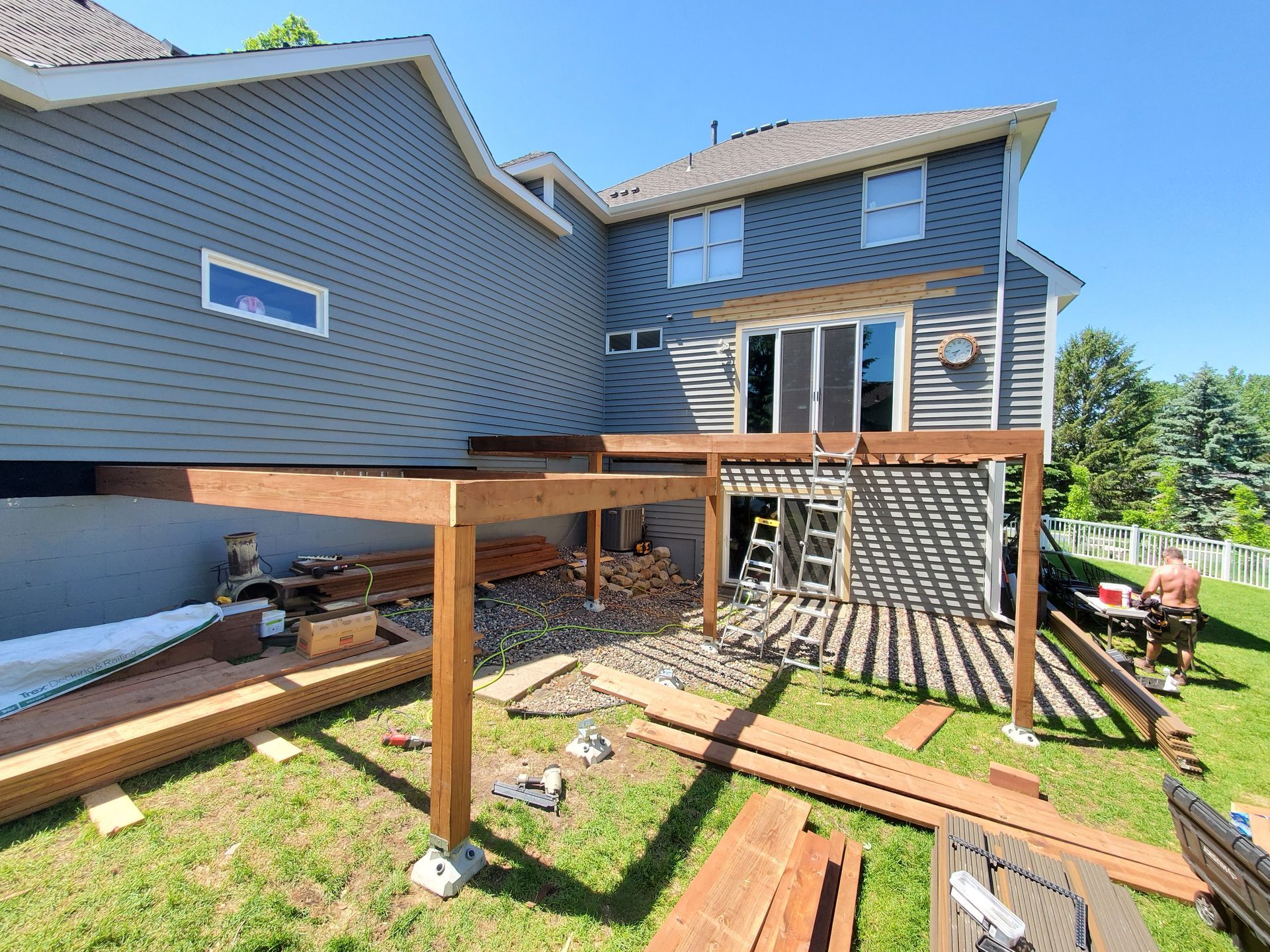 A house with a deck being built in the backyard.