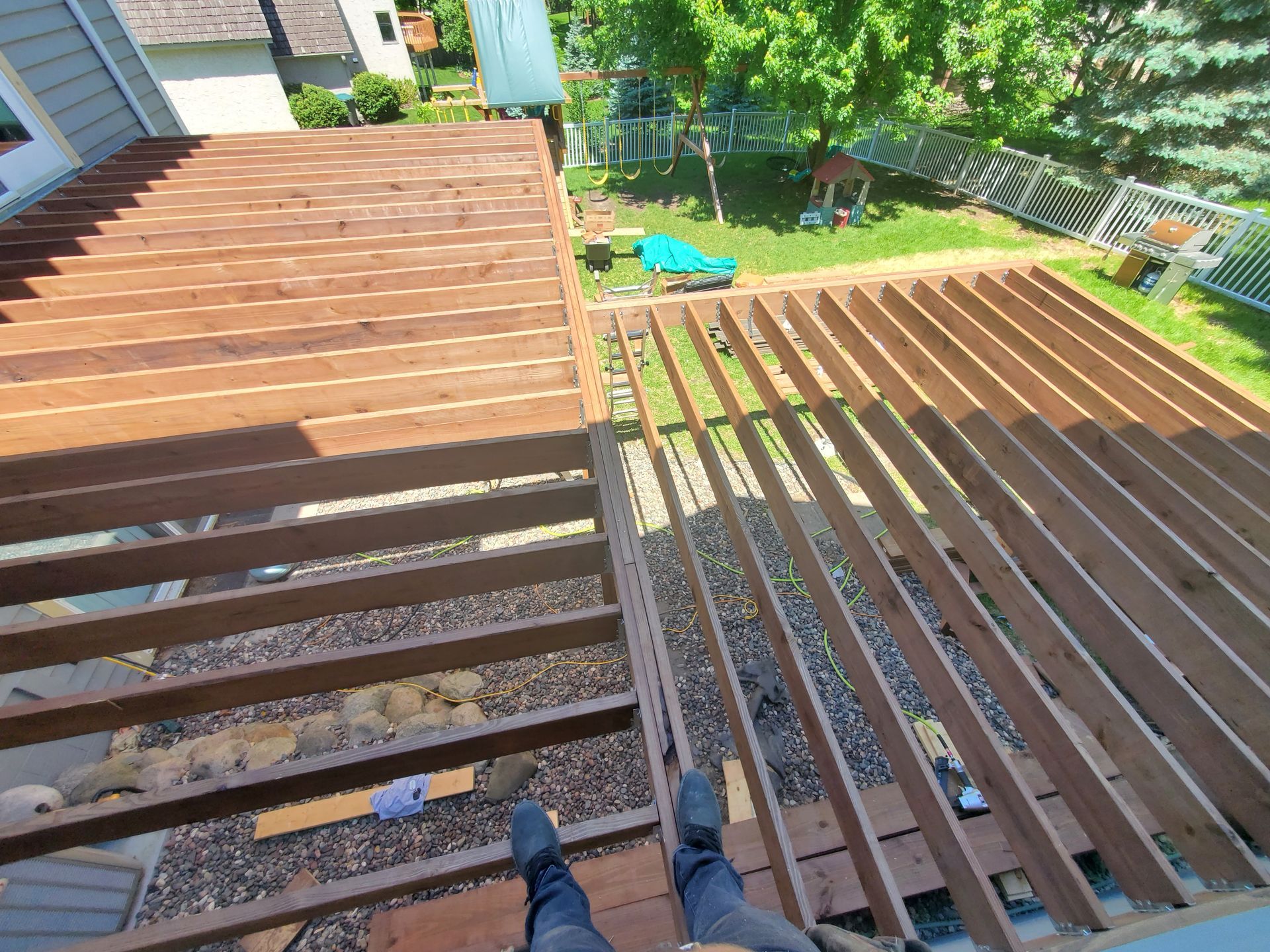A person is standing on top of a wooden deck.