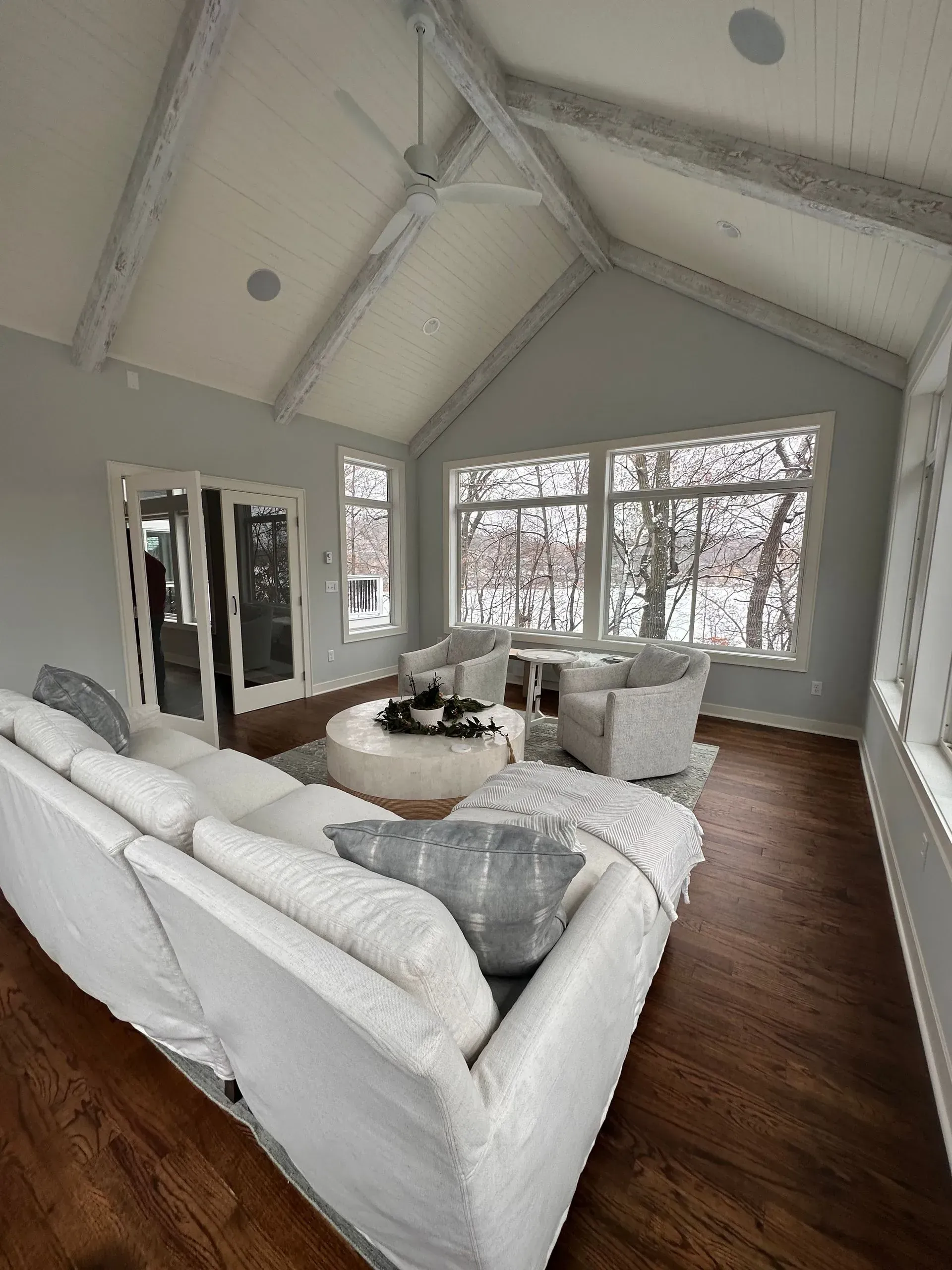 An empty room with a vaulted ceiling and lots of windows.