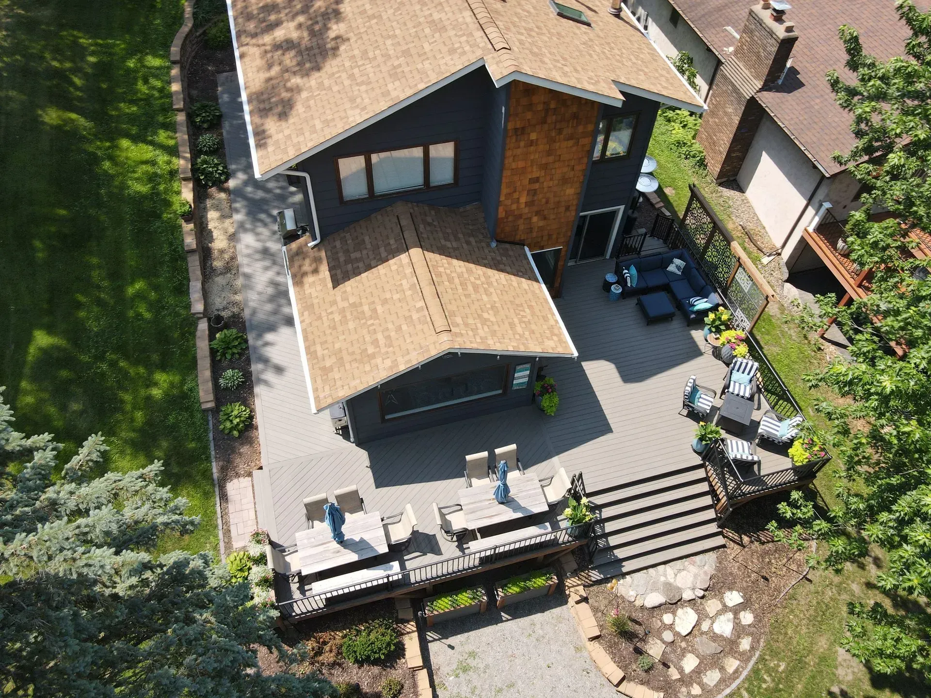 A large house is sitting on top of a lush green lawn next to a body of water.