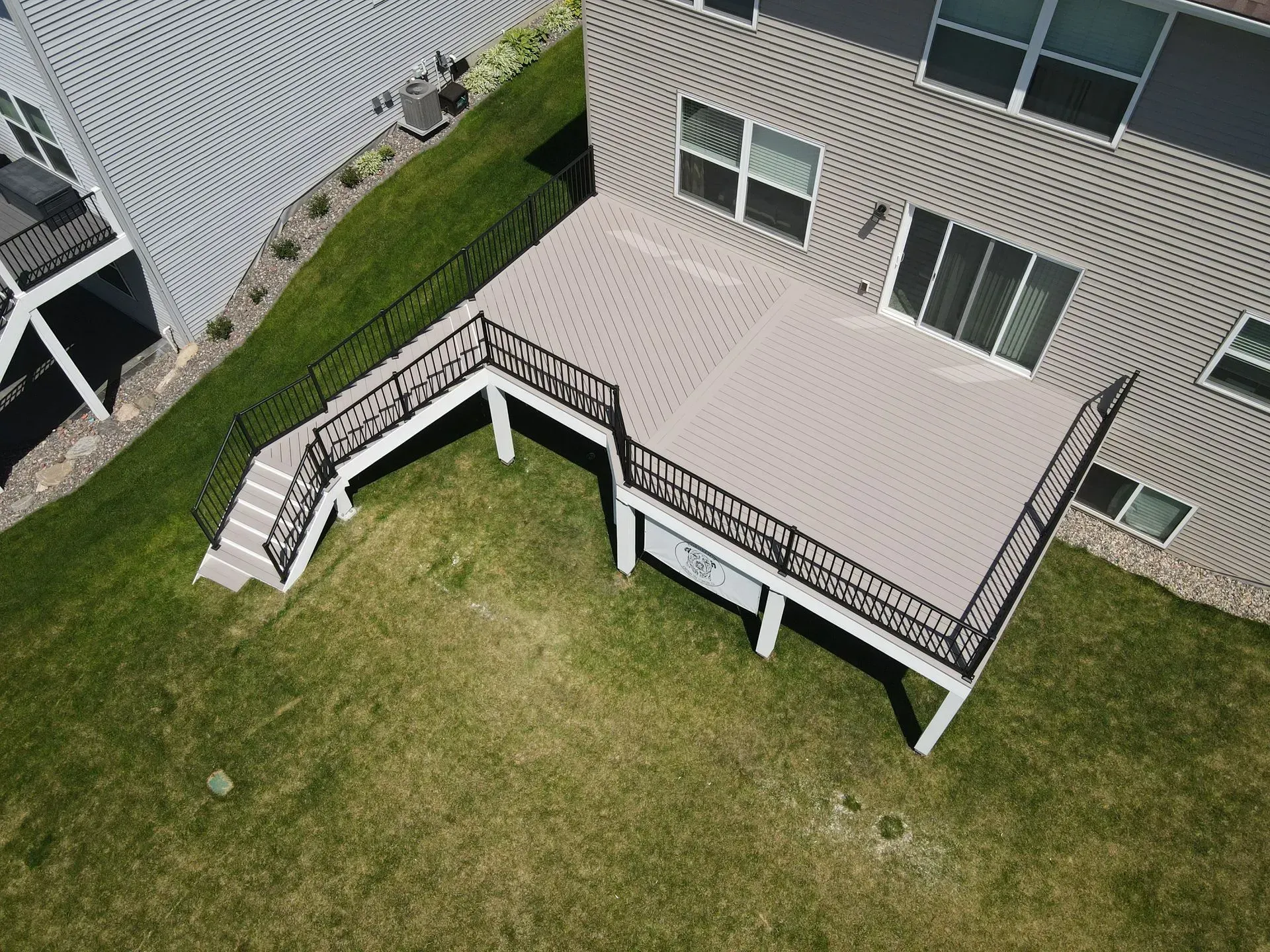 An aerial view of a large deck in the backyard of a house.