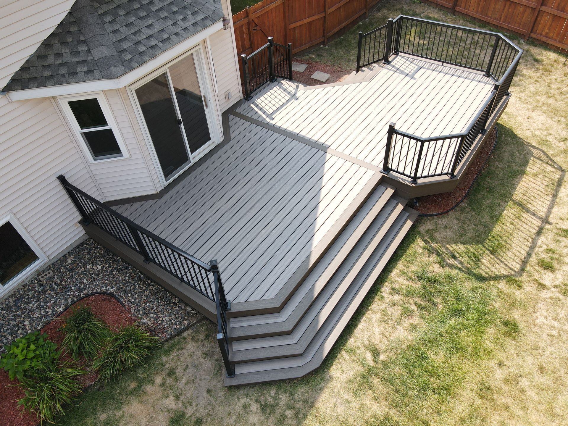 An aerial view of a large wooden deck with stairs leading up to it.
