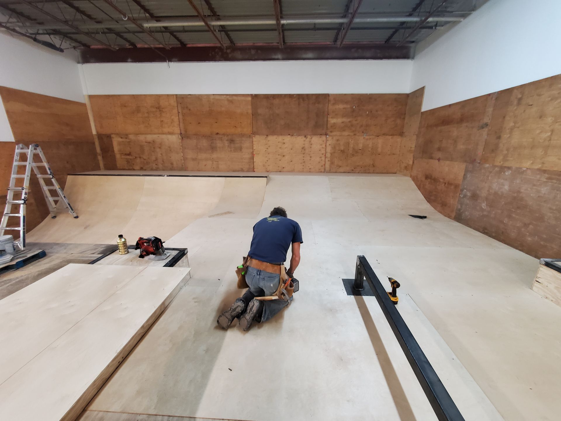 A man is working on a ramp in a warehouse.