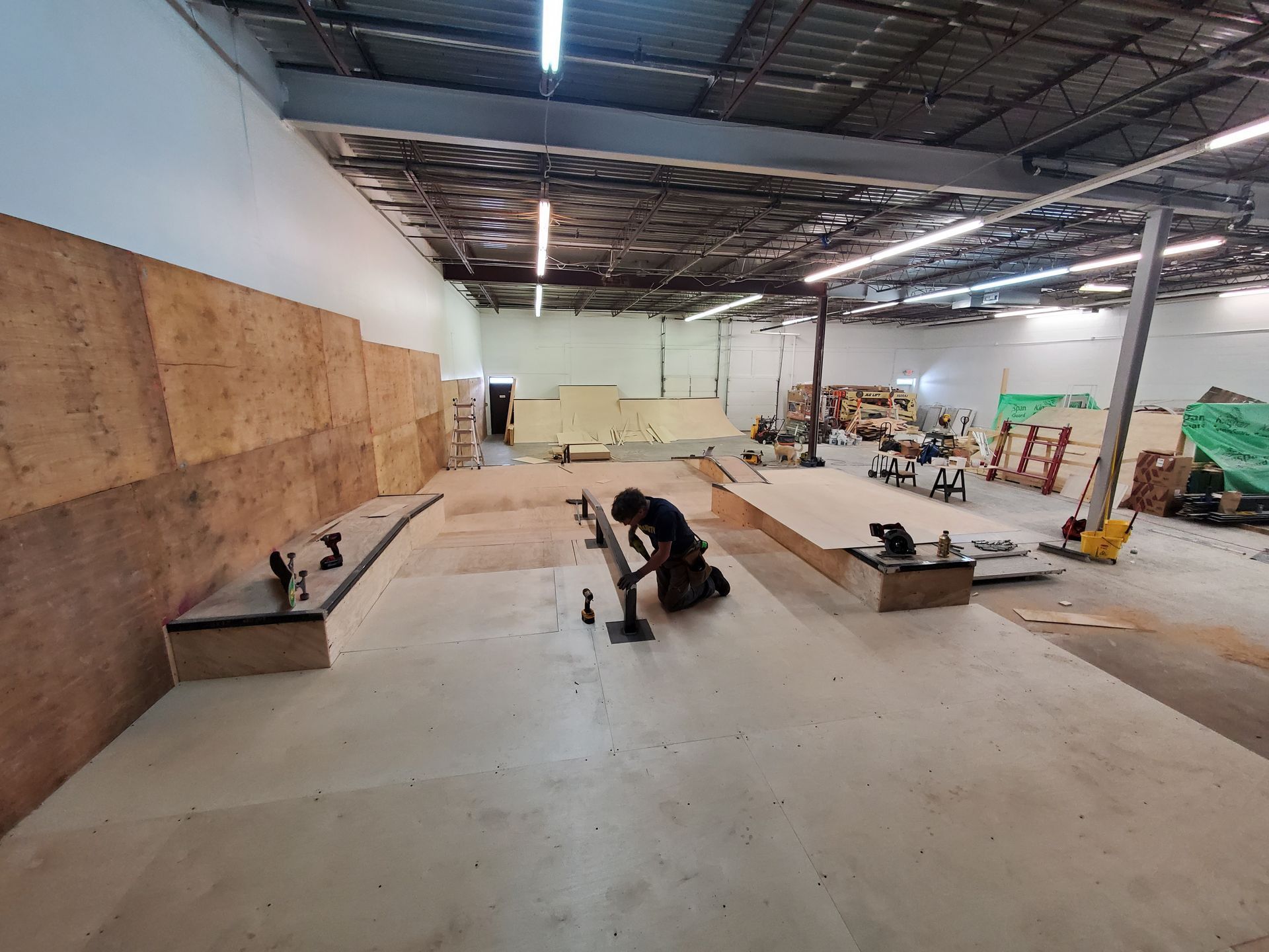 A man is working on a ramp in a warehouse.