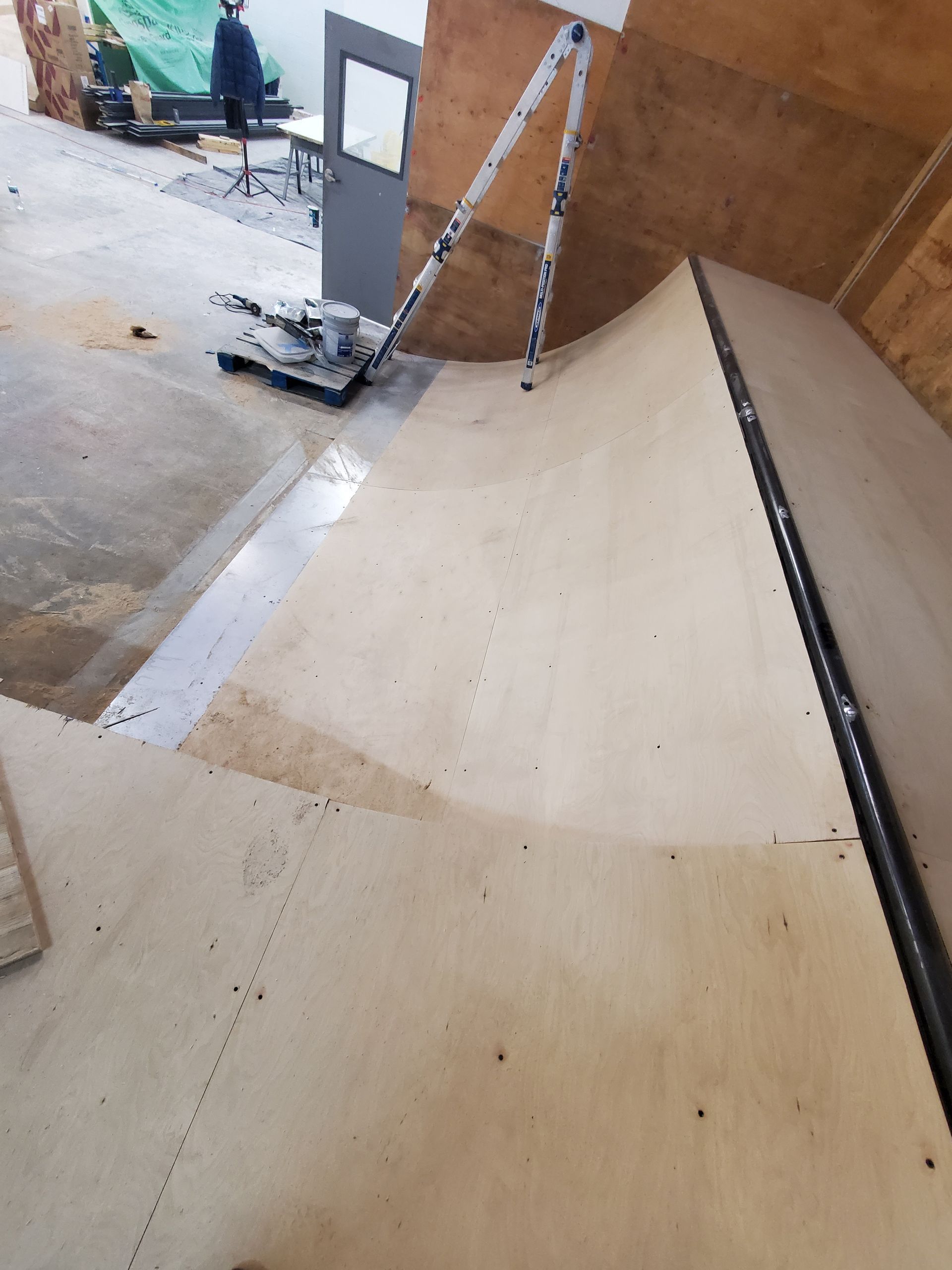 A skateboard ramp is being built in a garage