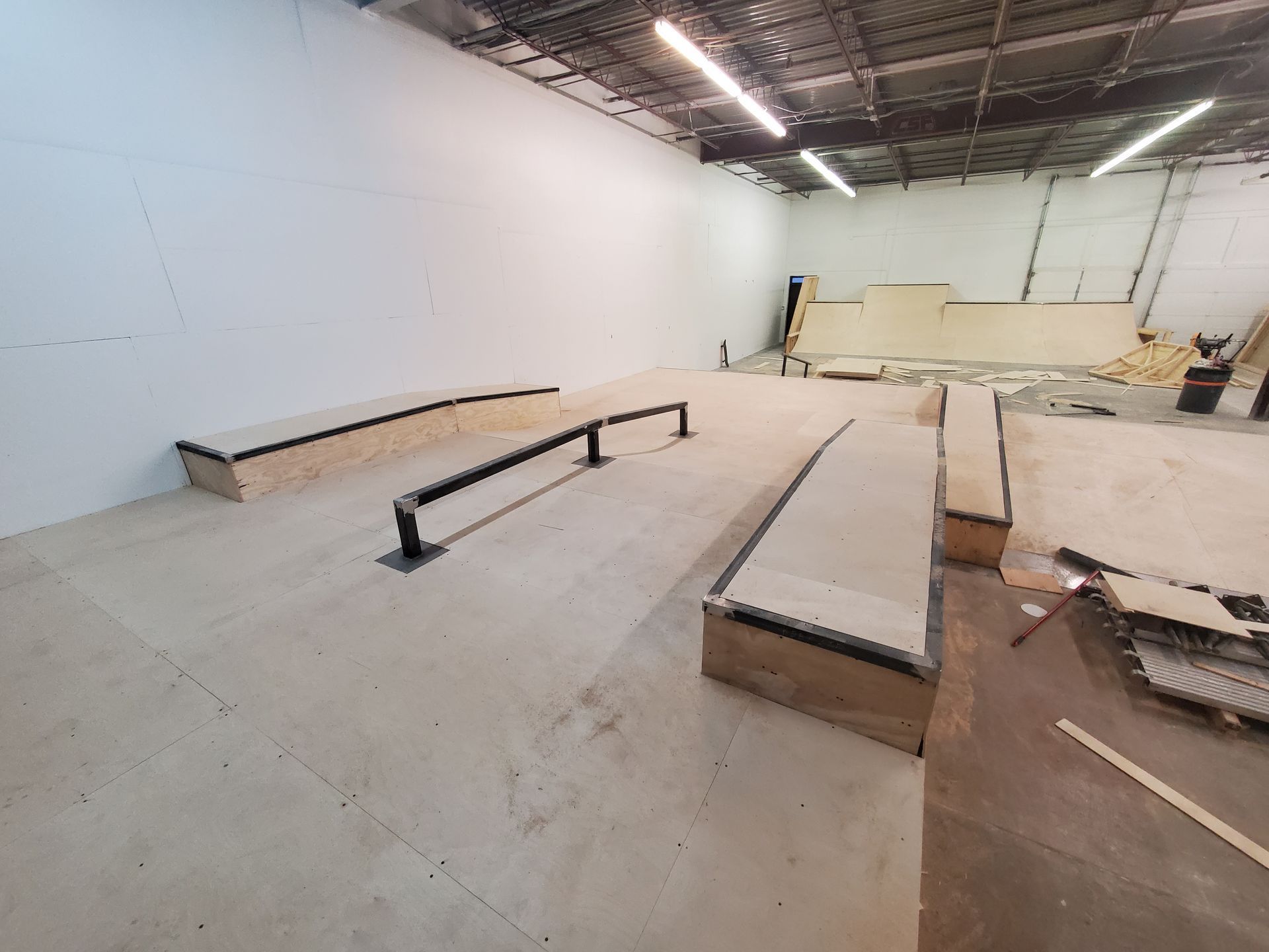 A skateboard park is being built in a warehouse.