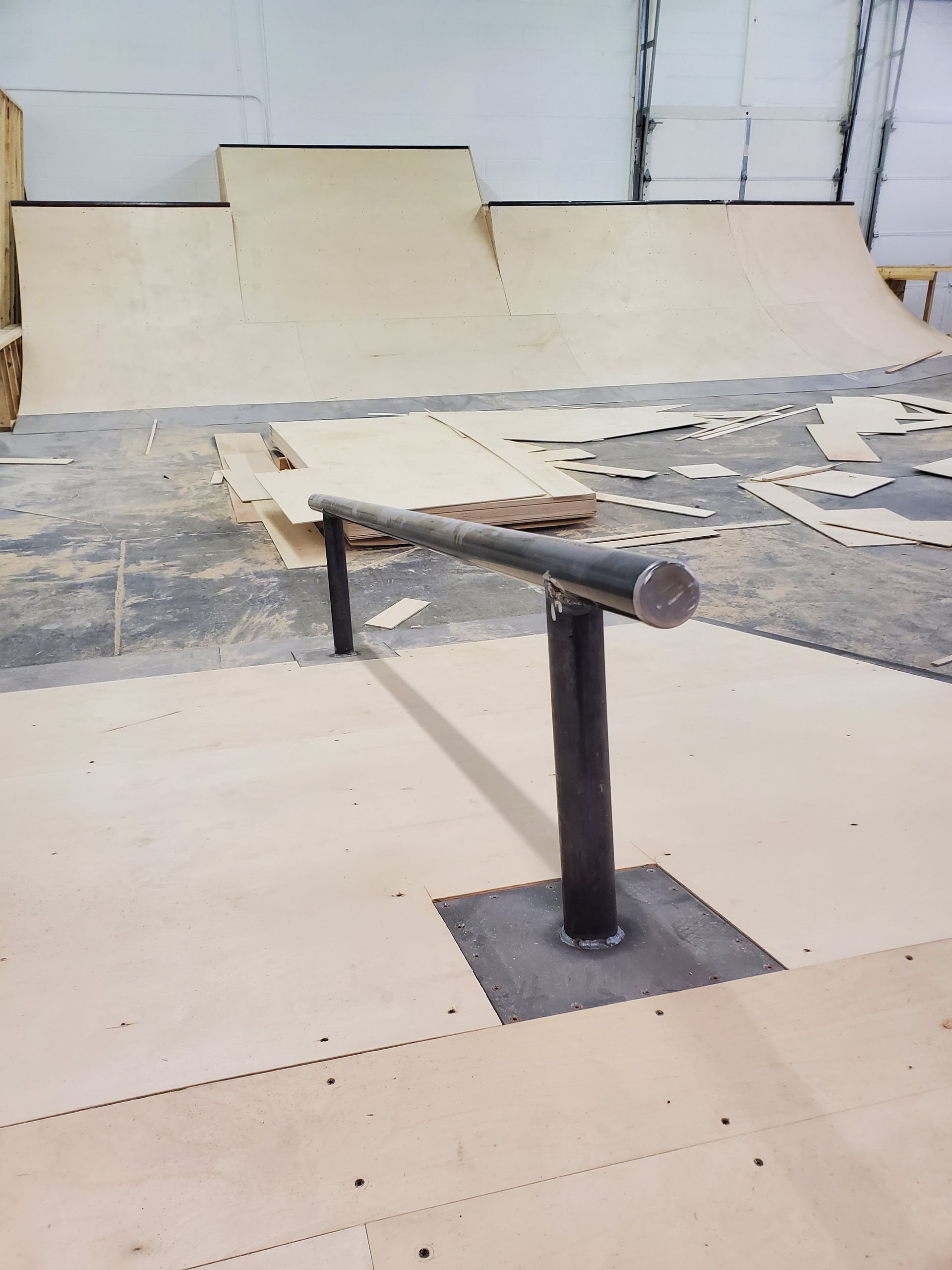 A skateboard ramp with a railing in the middle of it