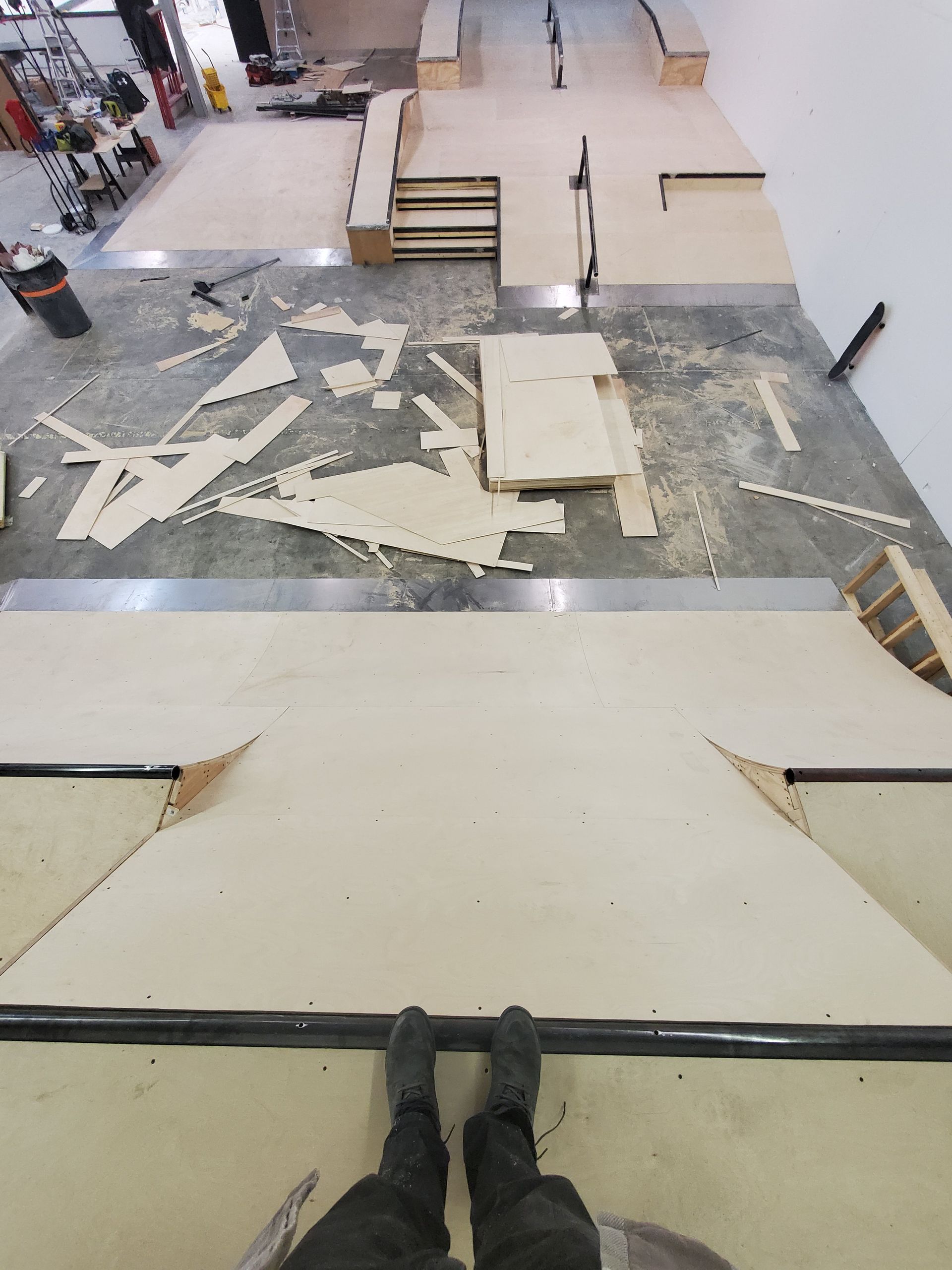 A person is standing on a ramp in a skate park.