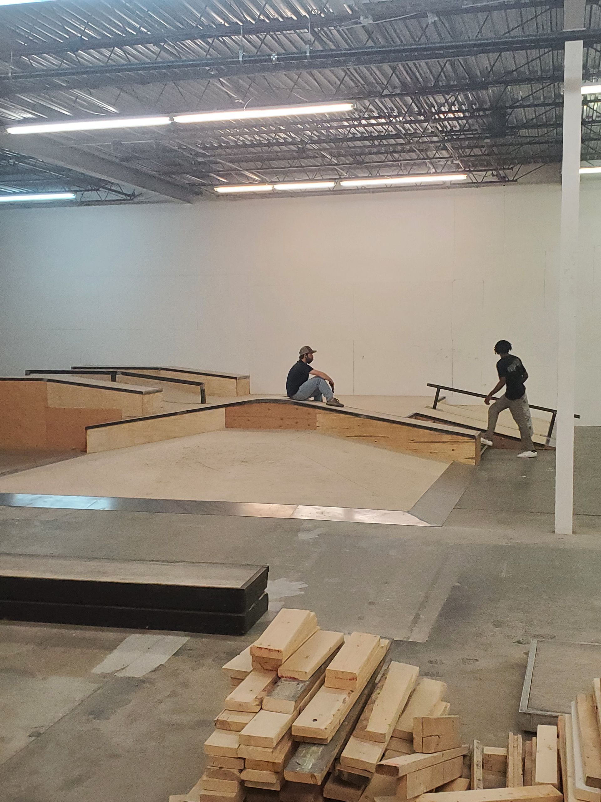 A man is riding a skateboard down a ramp in a warehouse