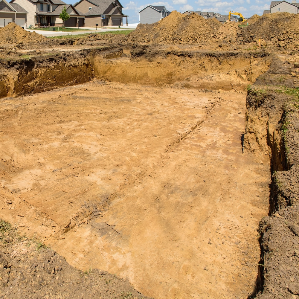 A large pile of dirt sits in the middle of a construction site