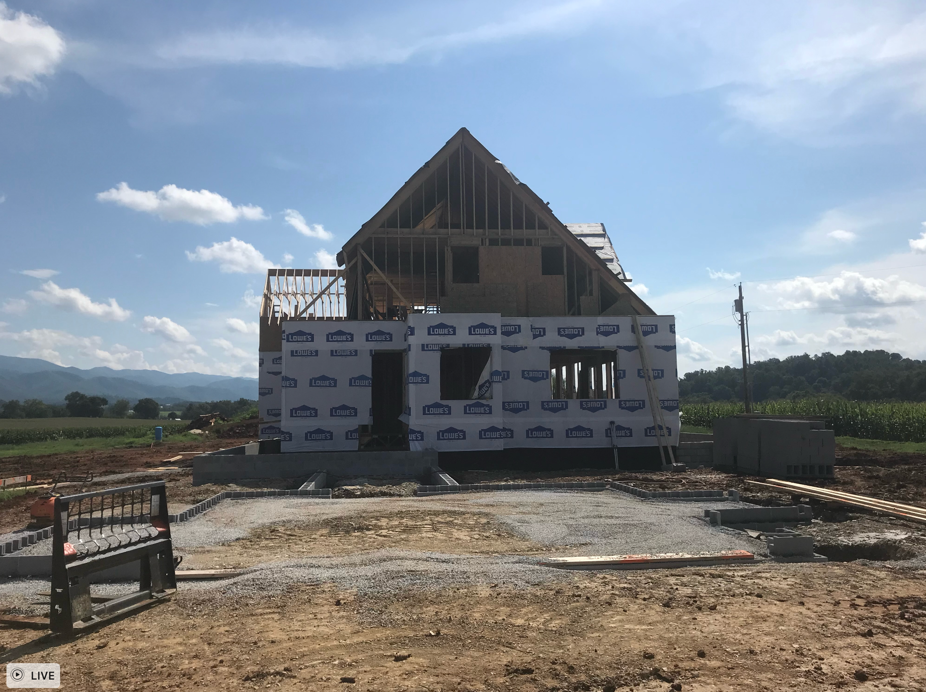 A house is being built in the middle of a dirt field.