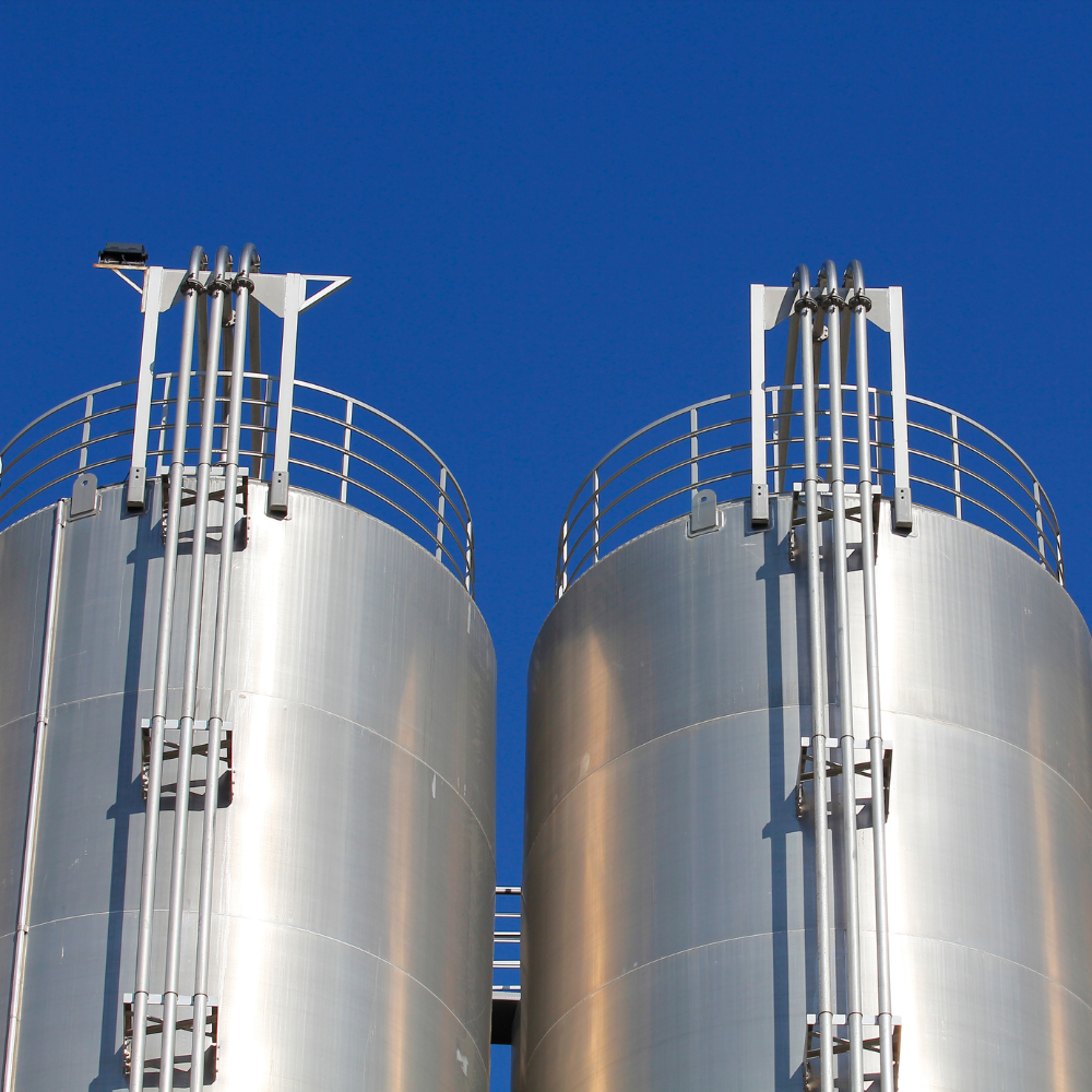 Two metal silos with a blue sky in the background