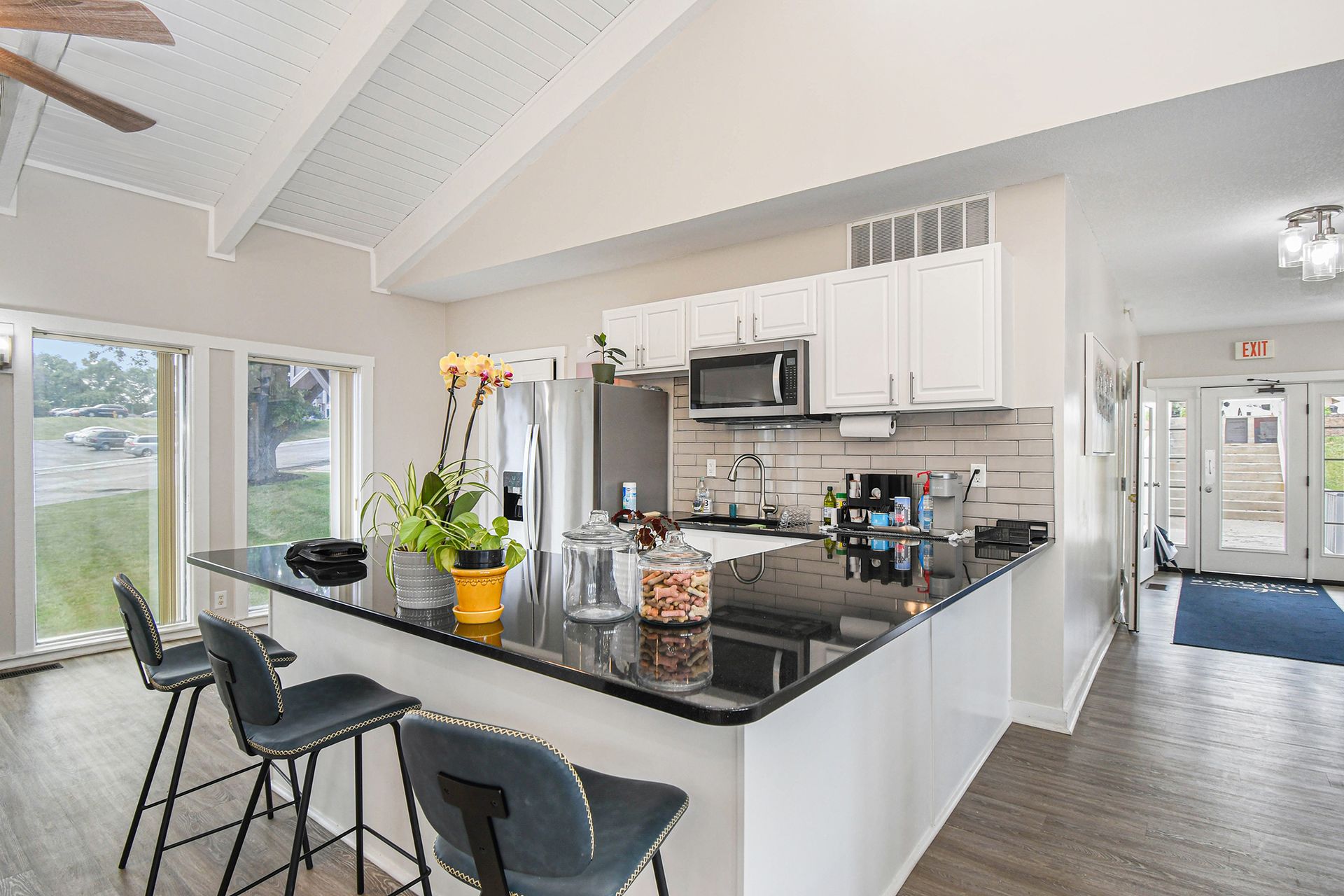 Kitchen with black countertop island, white cabinets, and stainless steel appliances.