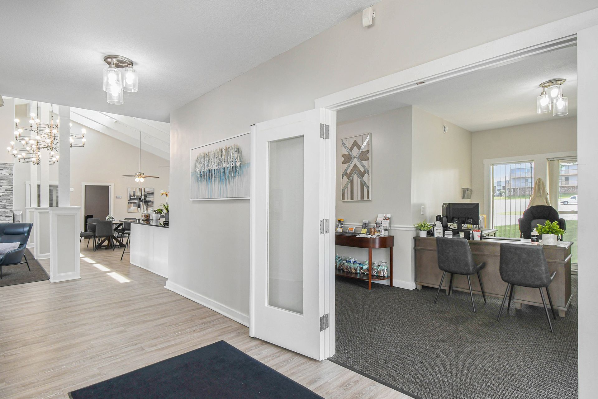 Interior of an office, with a reception area and open doorway to an employee's desk.