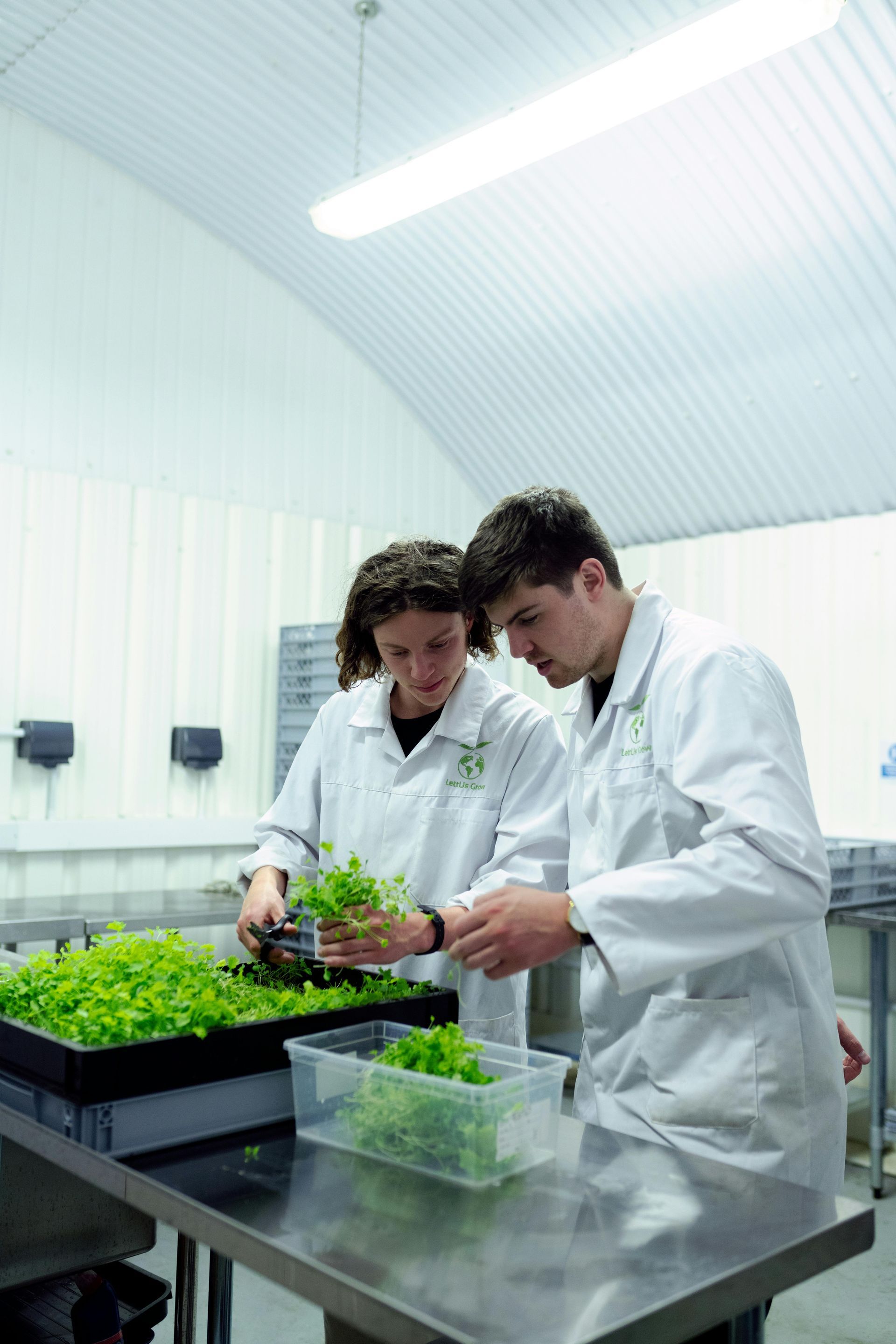Two men in white coats are working in a kitchen.