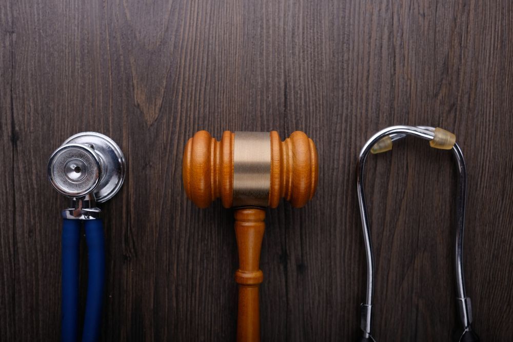 A Wooden Judge's Gavel and a Stethoscope Are on a Wooden Table — Chris Trevor & Associates in Central Highlands, QLD