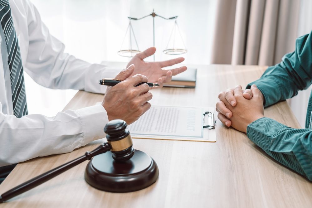 A Lawyer is Sitting at a Table Talking to a Client — Chris Trevor & Associates in Moranbah, QLD