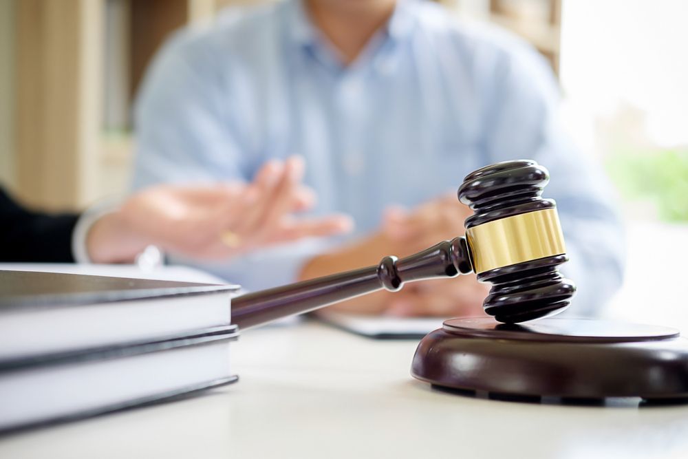 A Judge's Gavel is Sitting on a Table Next to a Stack of Books — Chris Trevor & Associates in Rockhampton, QLD