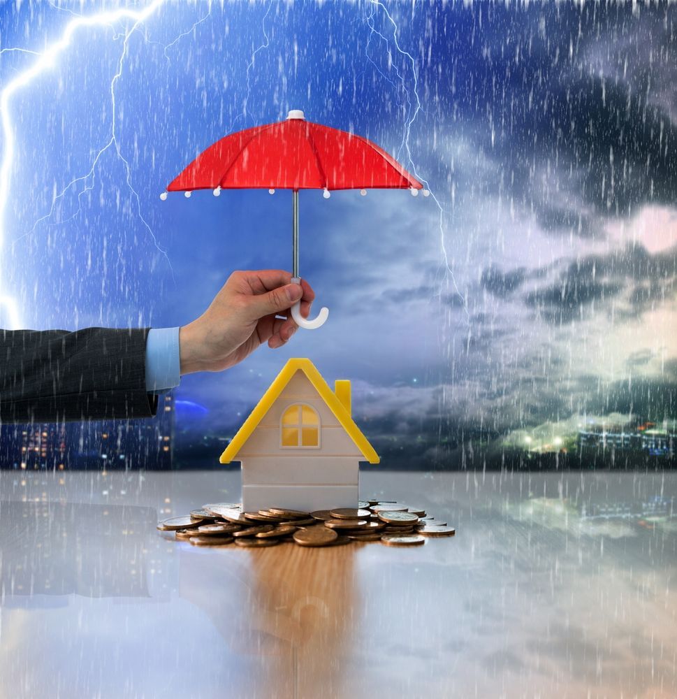 A Hand Holding Red Umbrella With House And Money — Chris Trevor & Associates in Gladstone Central, QLD