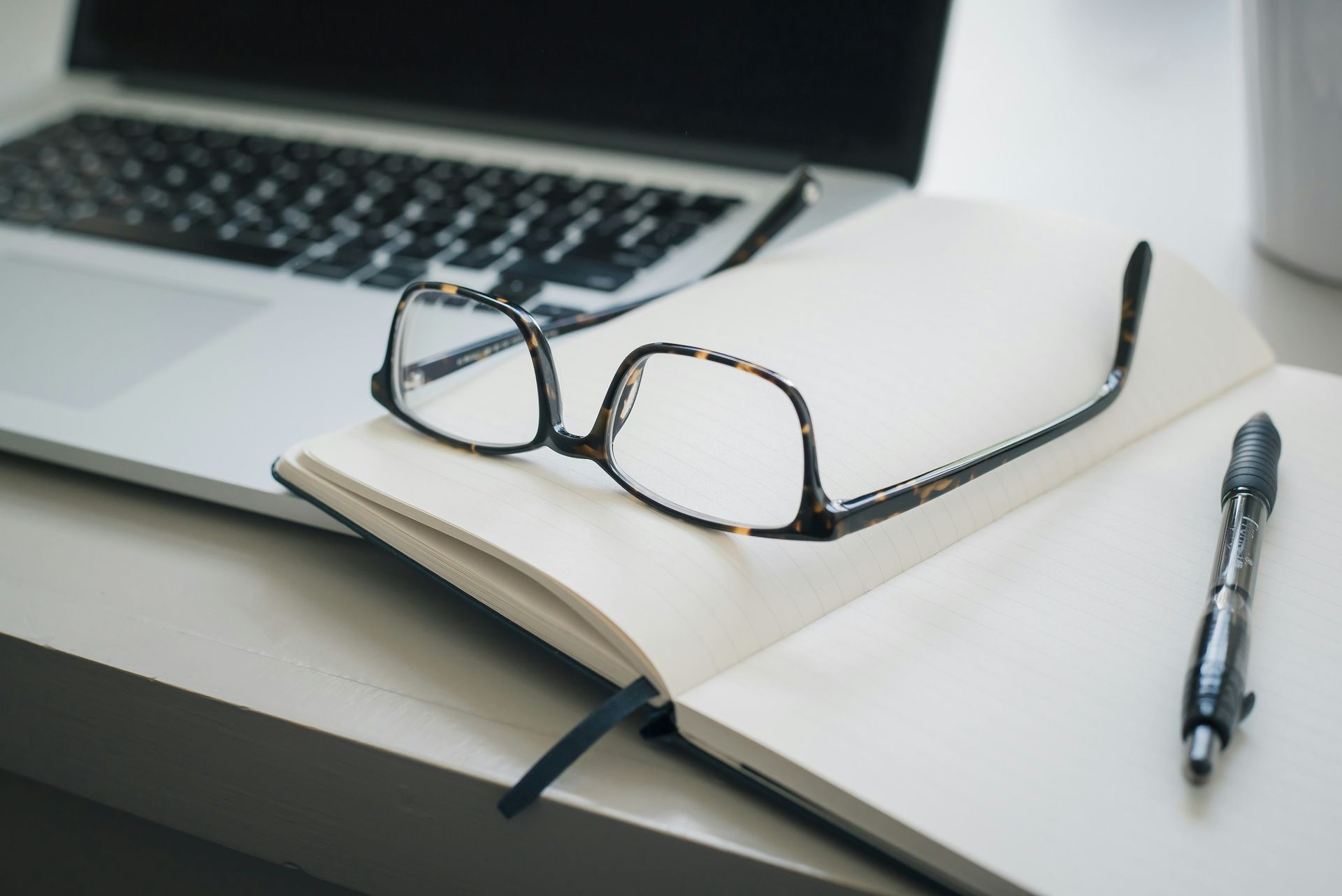 A Pair of Glasses Sitting on Top of an Open Notebook — Chris Trevor & Associates in Gladstone Central, QLD