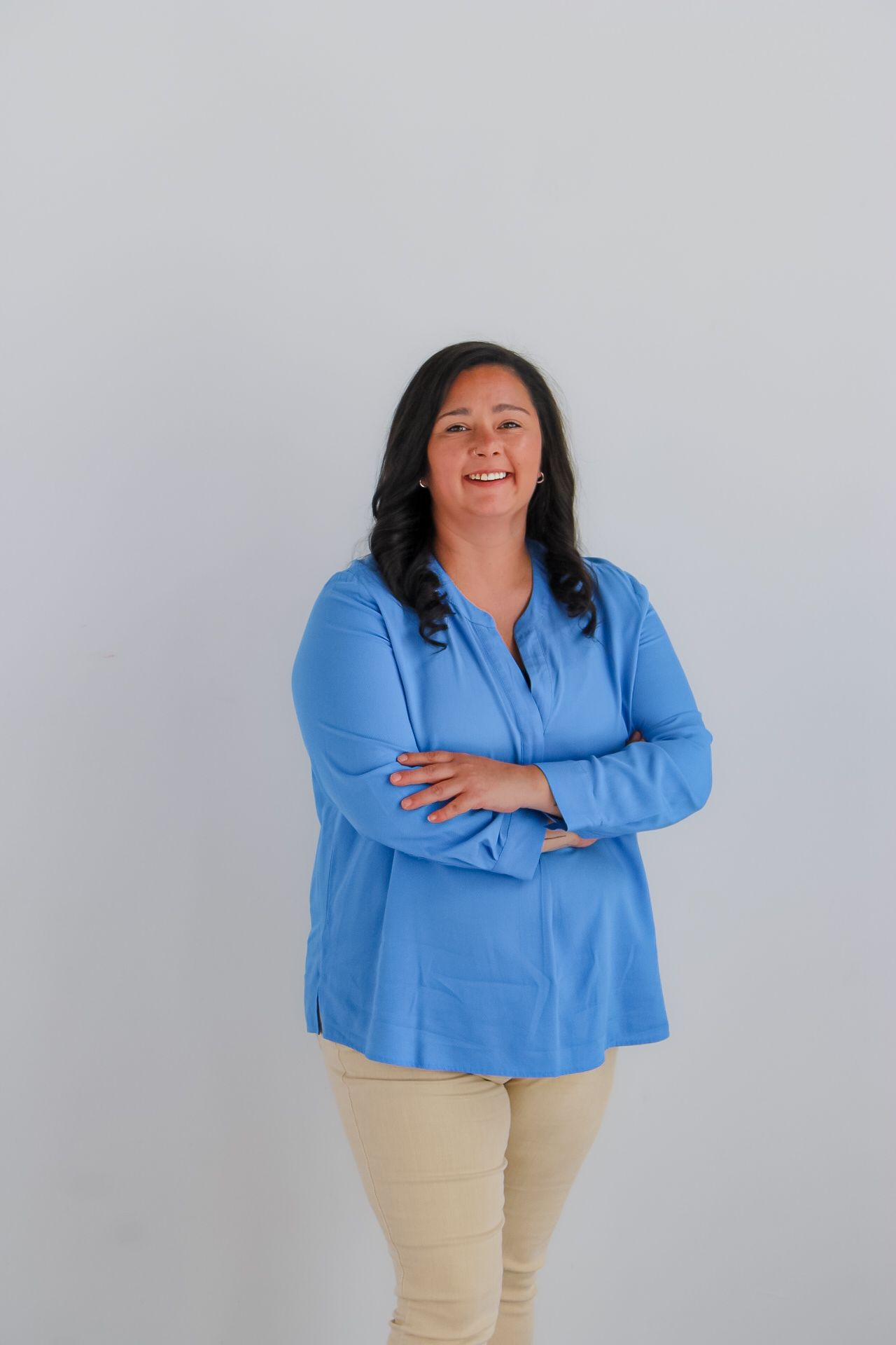 A woman in a purple shirt is smiling for the camera.