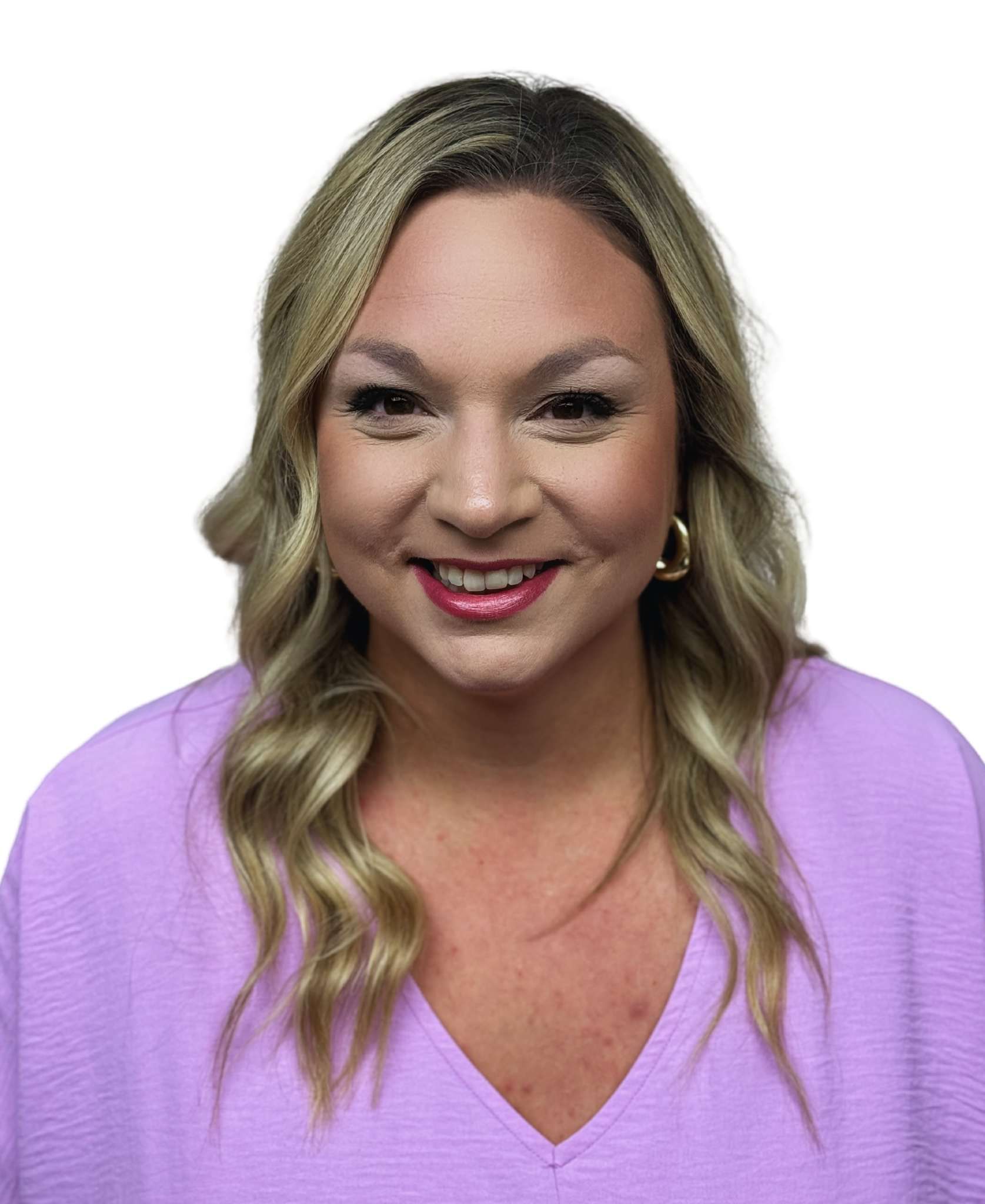 A woman in a purple shirt is smiling for the camera.